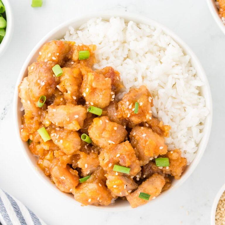 Orange Chicken and rice in a white bowl.