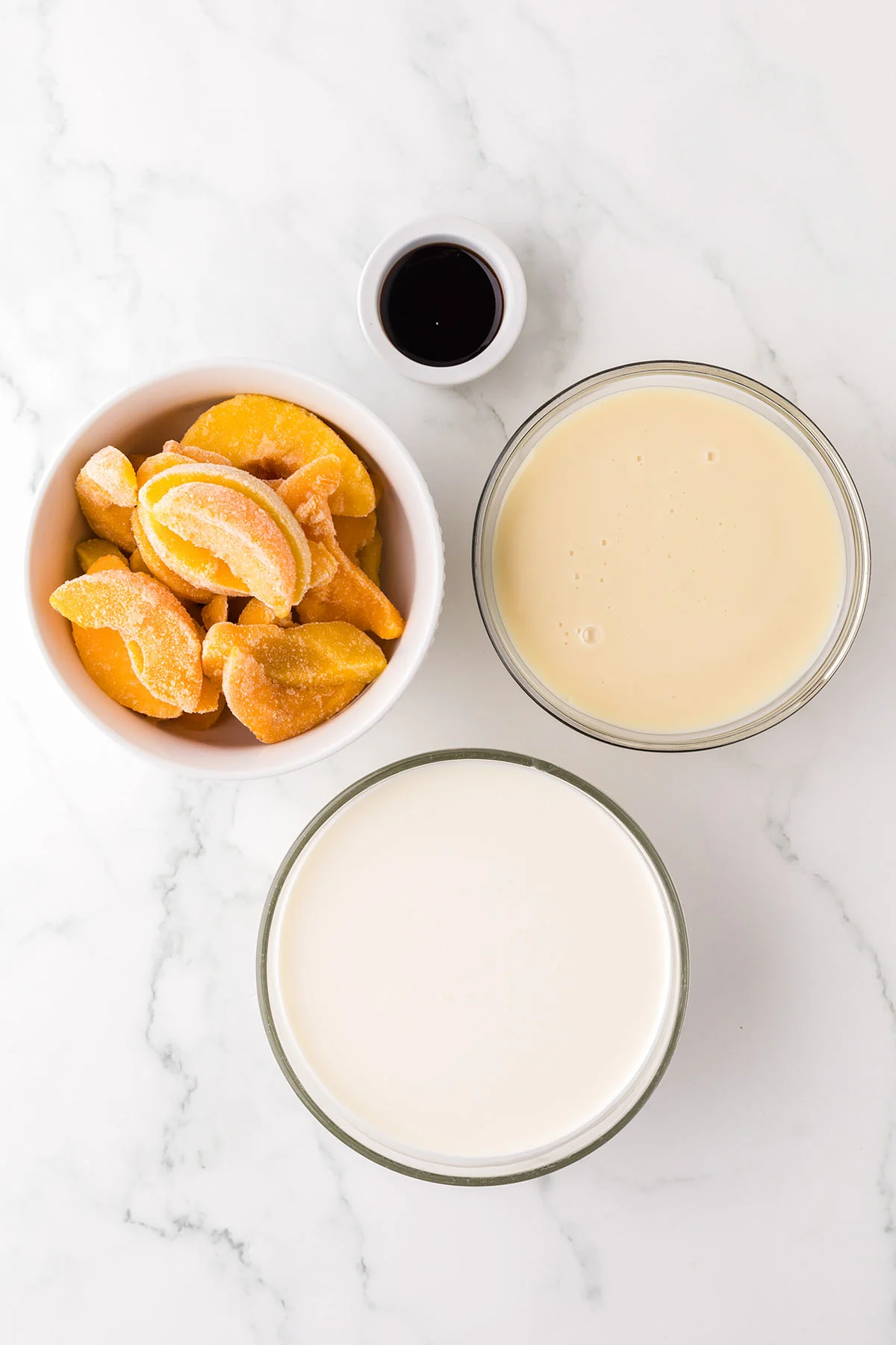Ingredients to make peach ice cream are set out on the counter.