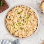 Parmesan Risotto served in a white bowl, topped with chopped parsley.