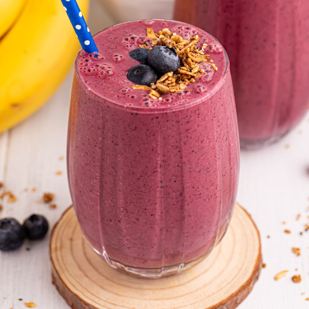 Blueberry Mango Smoothie served in a glass topped with blueberries and granola.