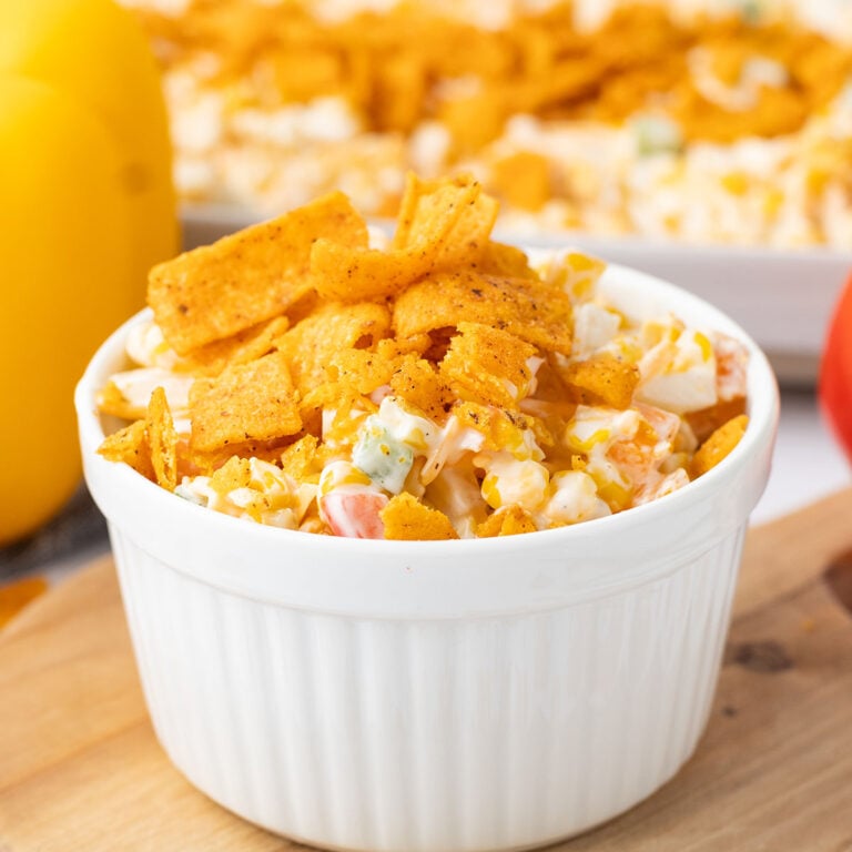 A serving of Frito corn salad in a white bowl.