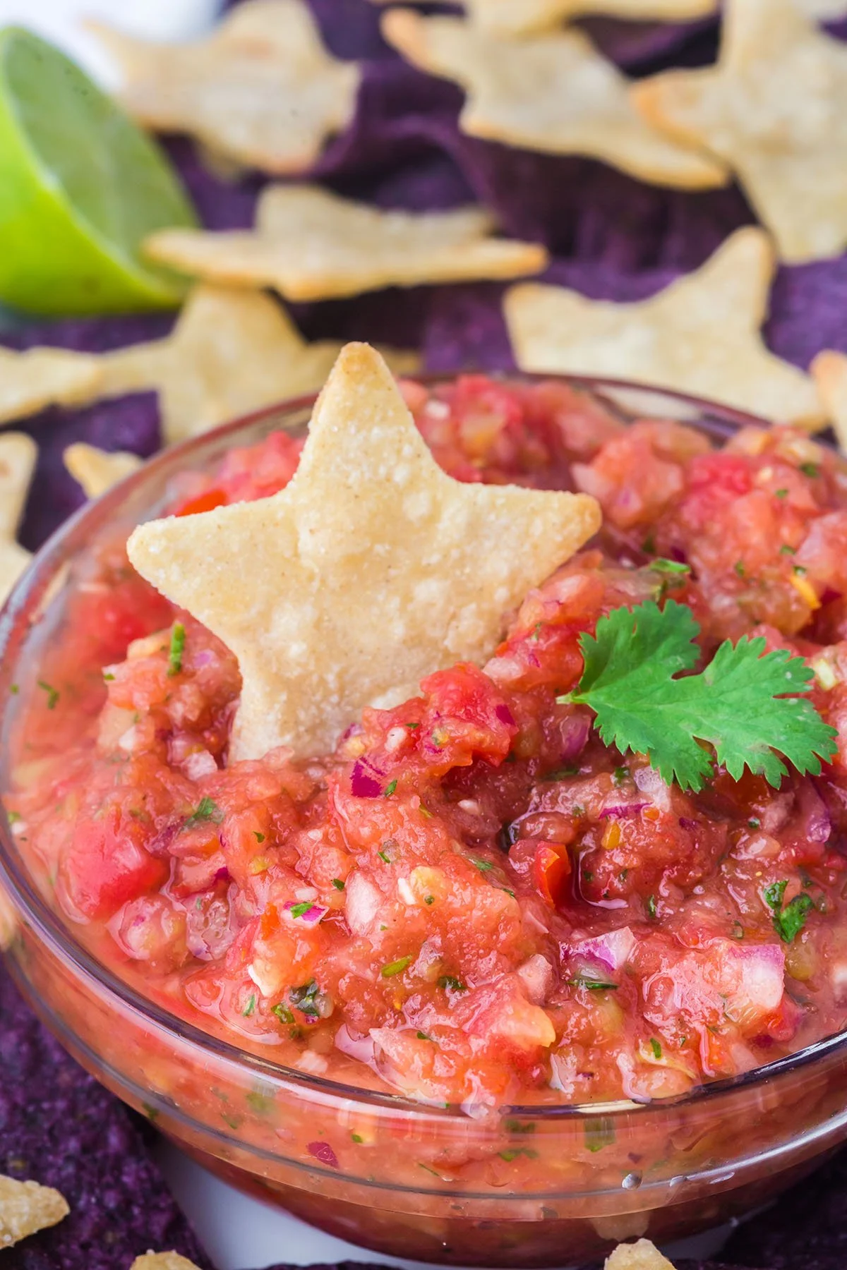 Salsa in a glass bowl topped with a star chip.