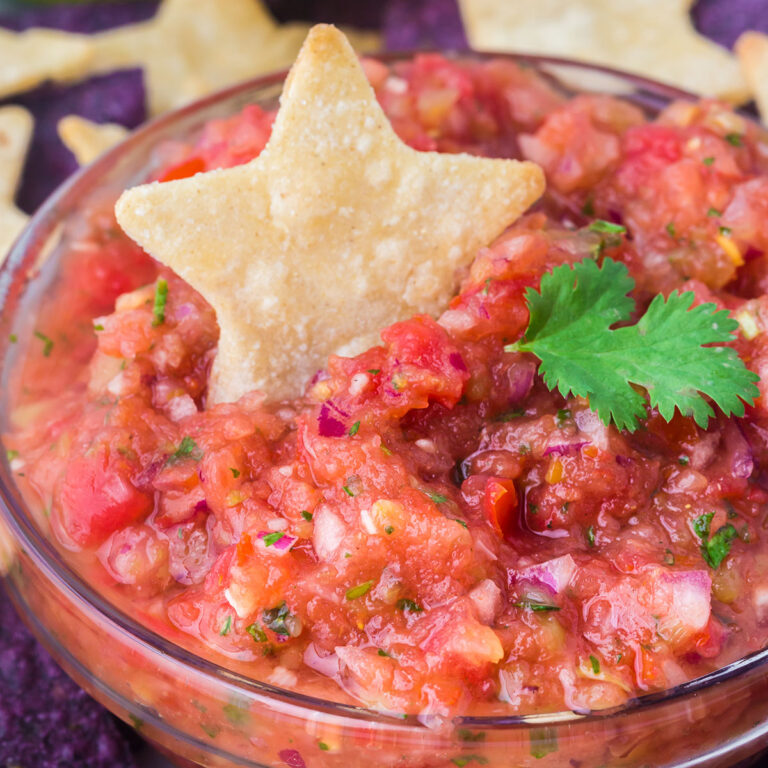 Salsa in a clear bowl topped with a star chip.