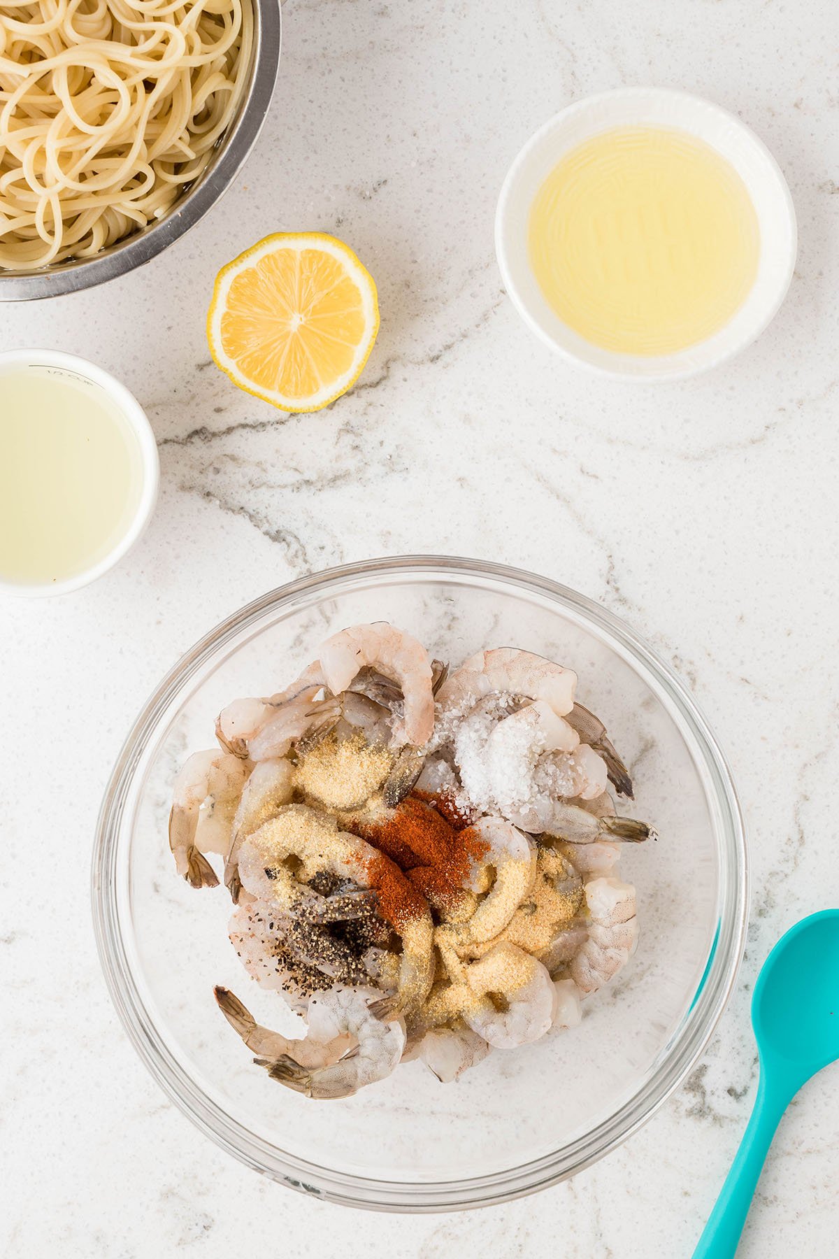 Shrimp, garlic powder, onion powder, sea salt, black pepper, and paprika in a glass mixing bowl.