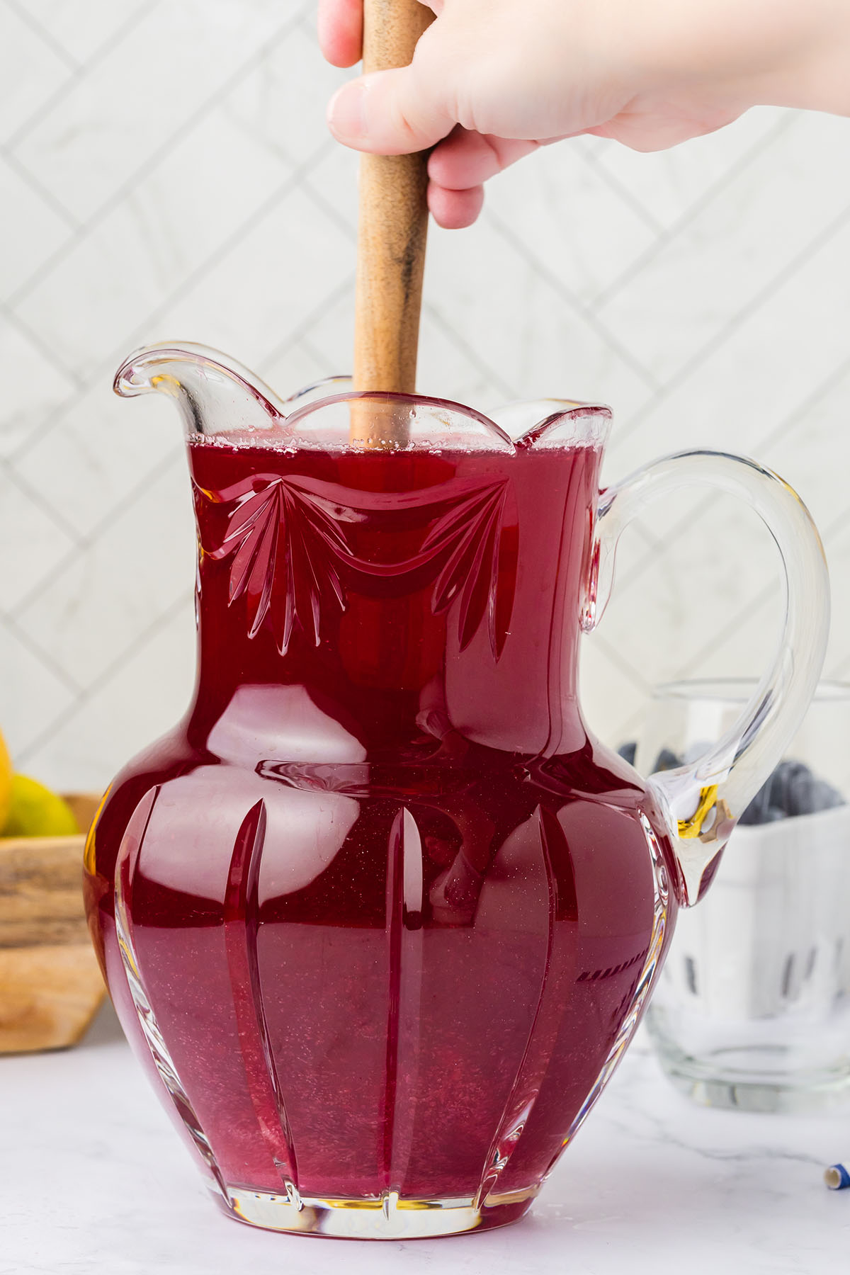 Stirring the blueberry lemonade in the glass pitcher.