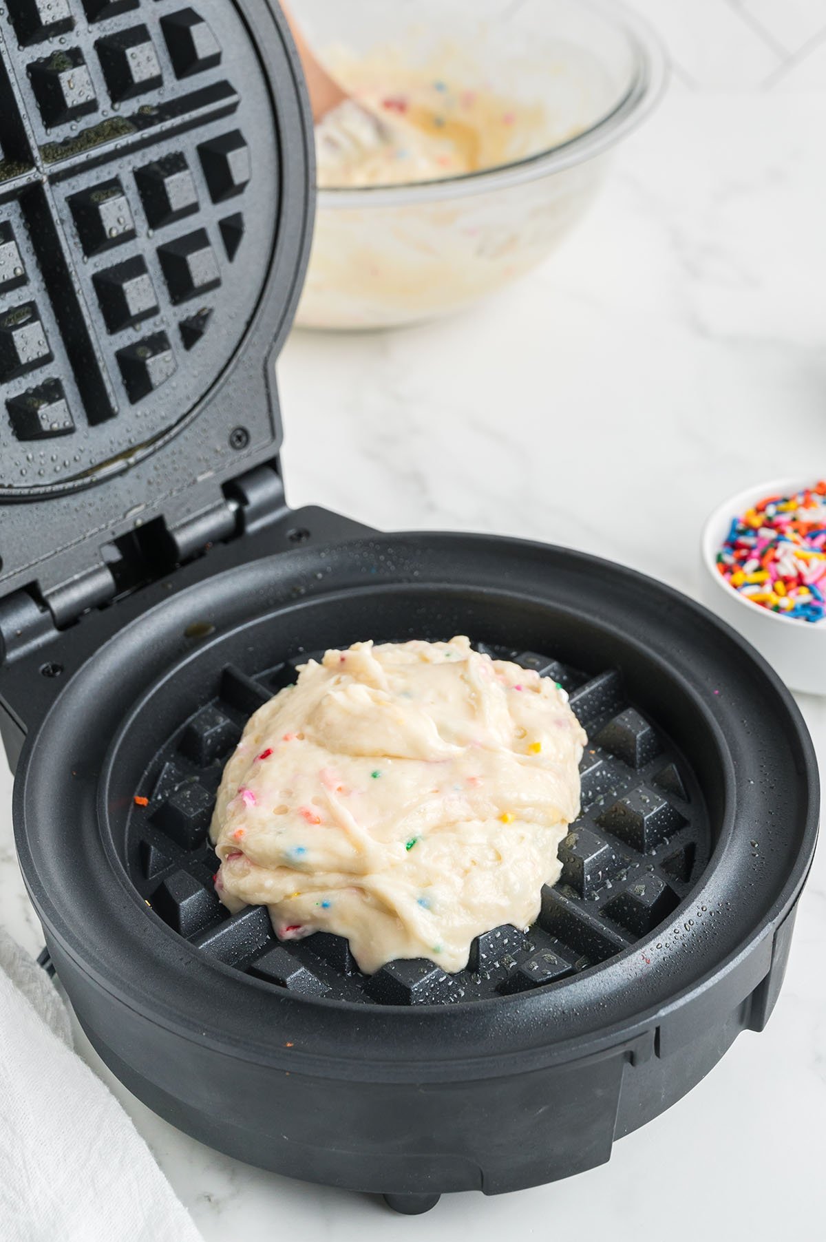 Birthday Cake Waffle batter poured into the waffle iron.