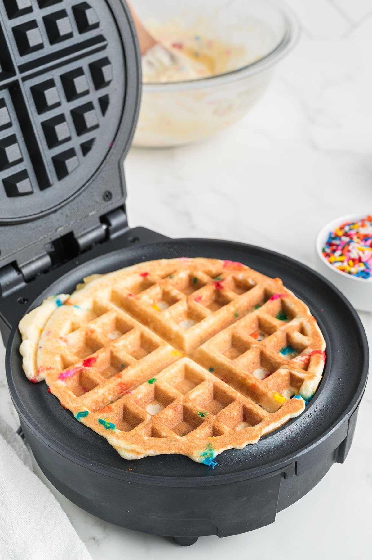 Cooked Birthday Cake Waffle in a waffle iron.