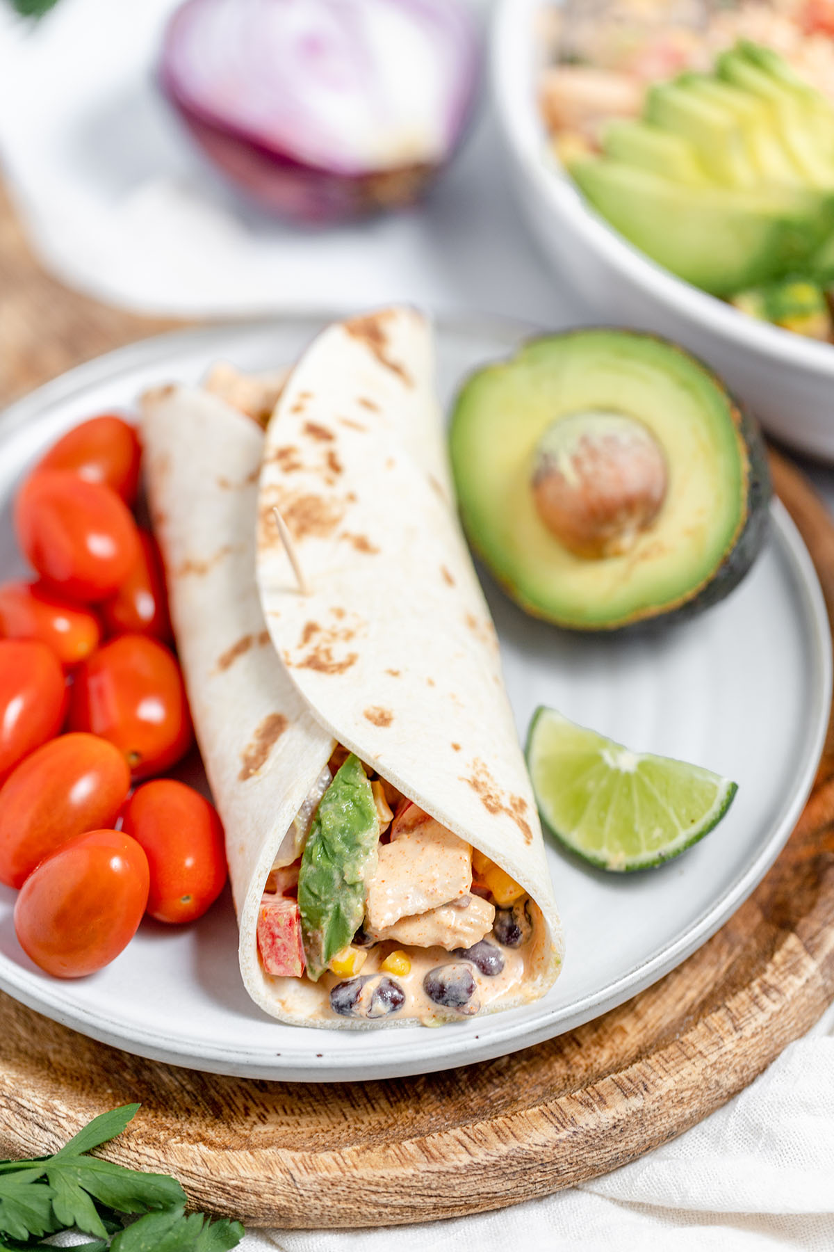 Southwest chicken salad wrapped in a flour tortilla and served with tomatoes and avocado. 