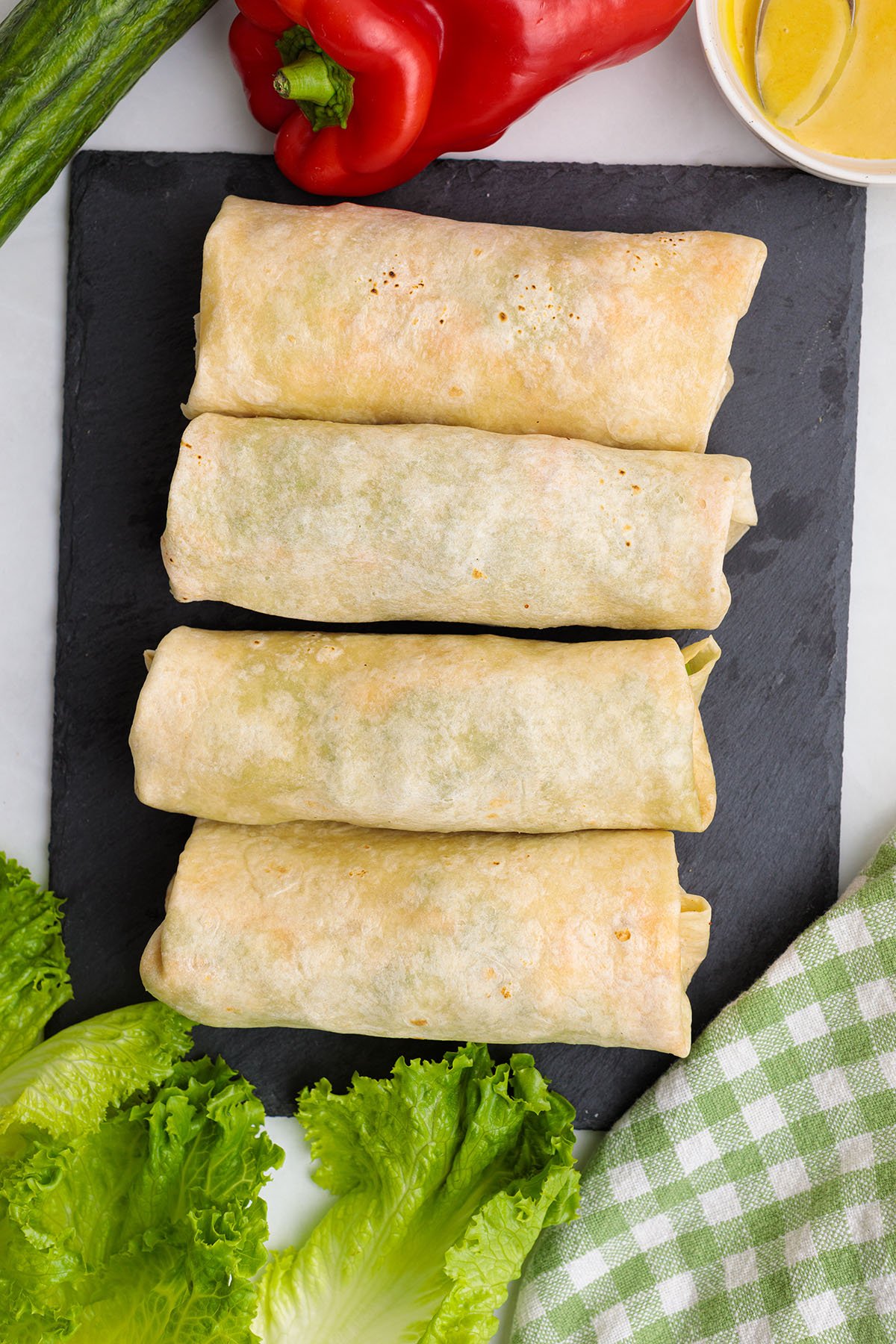 Honey Mustard Chicken Wraps rolled up on a cutting board.