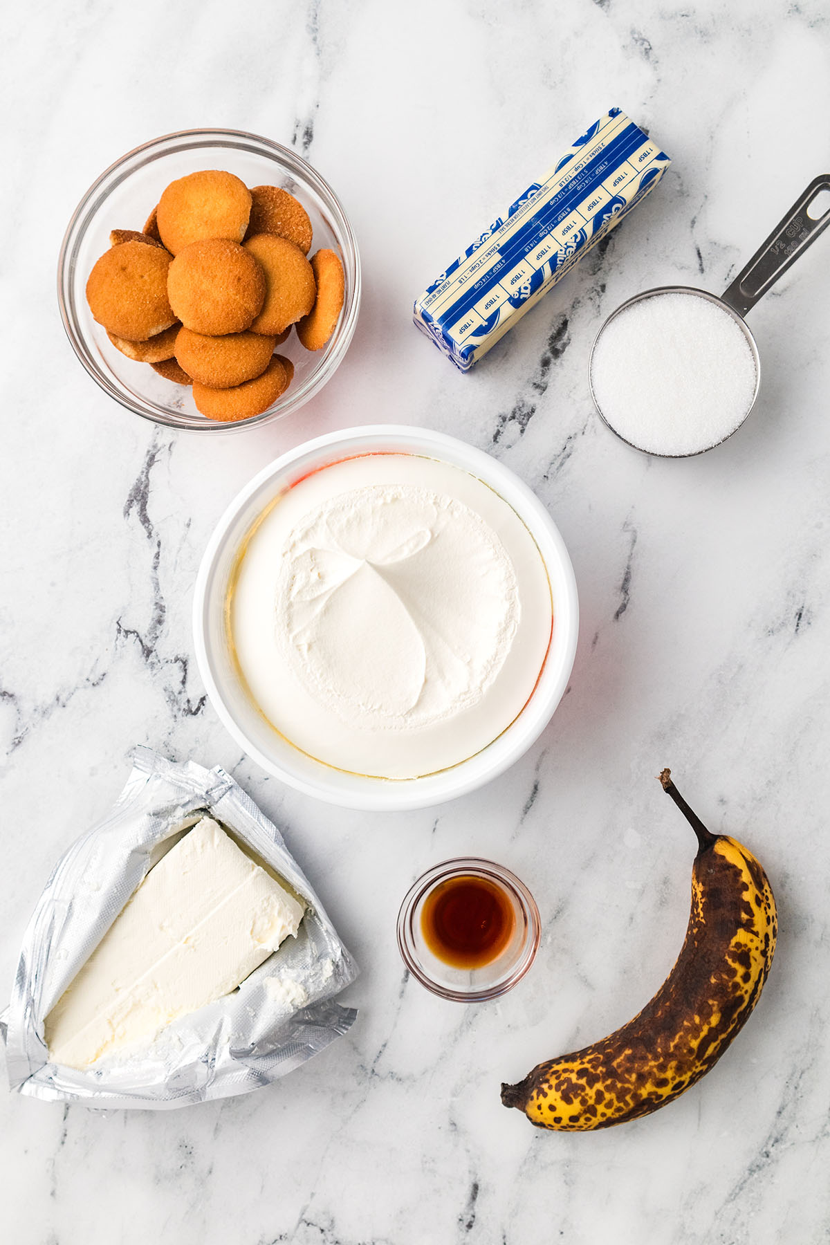 Ingredients to make mini banana cheesecakes are set out on the counter.