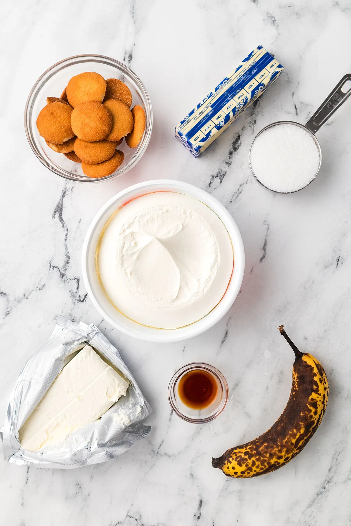 Ingredients to make mini banana cheesecakes are set out on the counter.