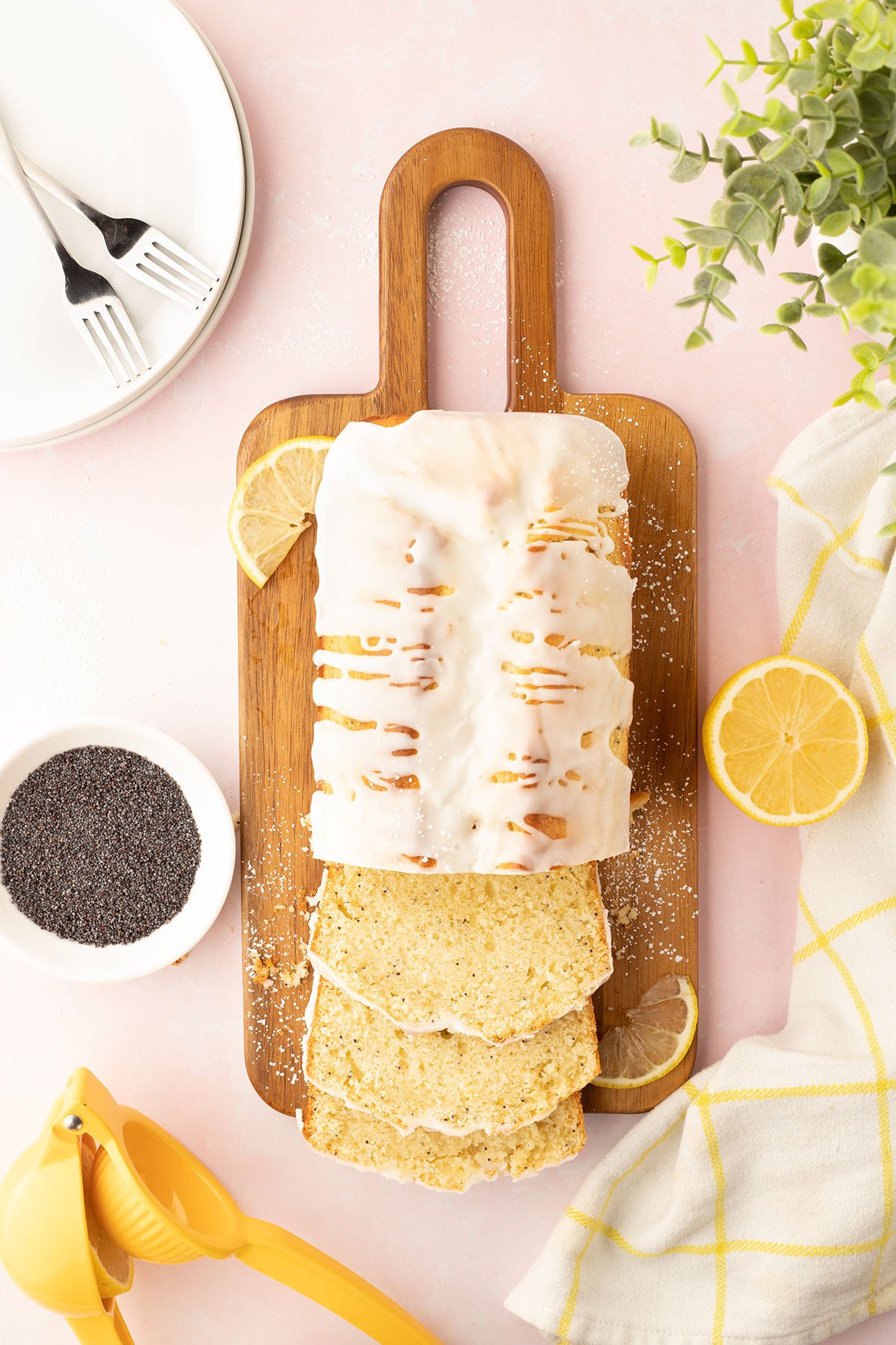 Lemon Poppy Seed Bread on a wooden serving board, with three slices cut.