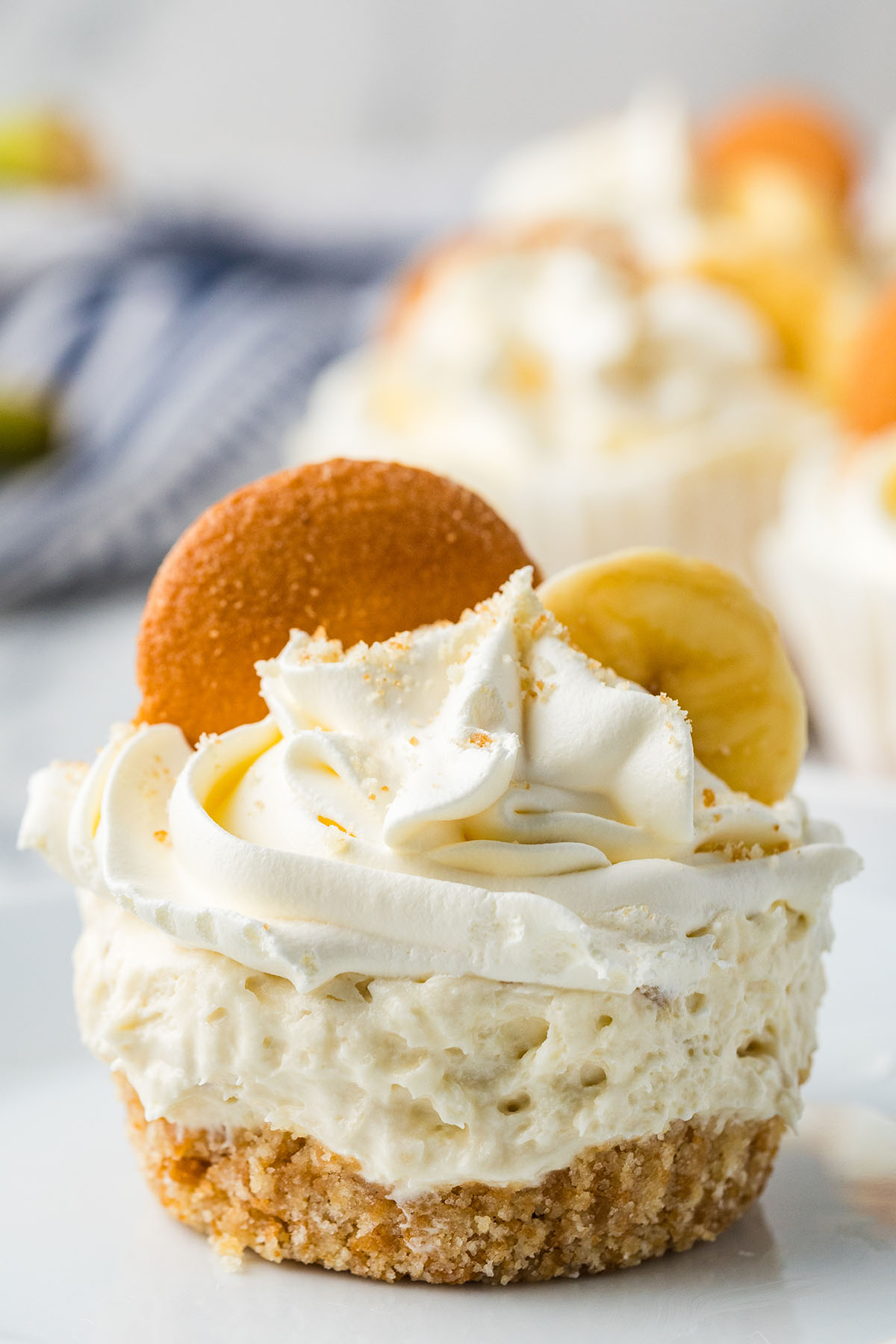 Mini Banana Cheesecakes topped with a slice of banana and a vanilla wafer.