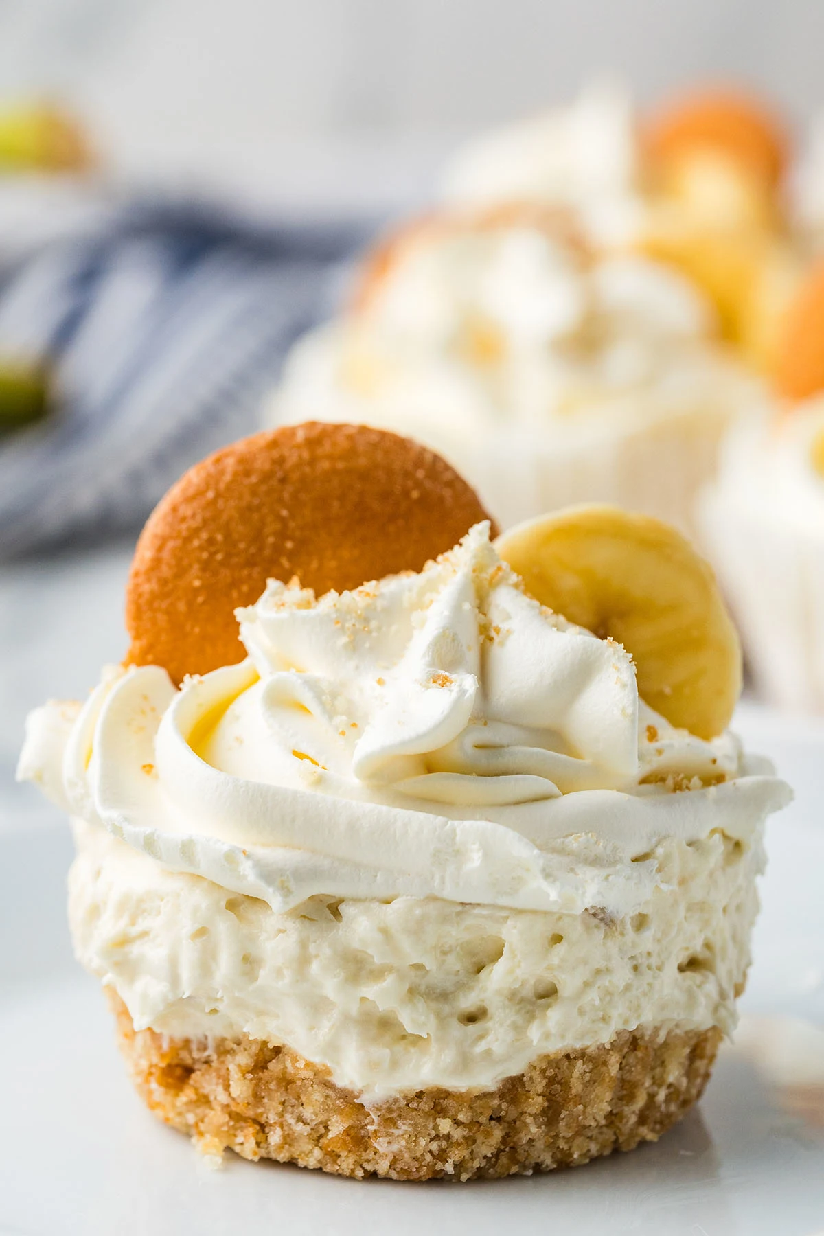Mini Banana Cheesecakes topped with a slice of banana and a vanilla wafer.