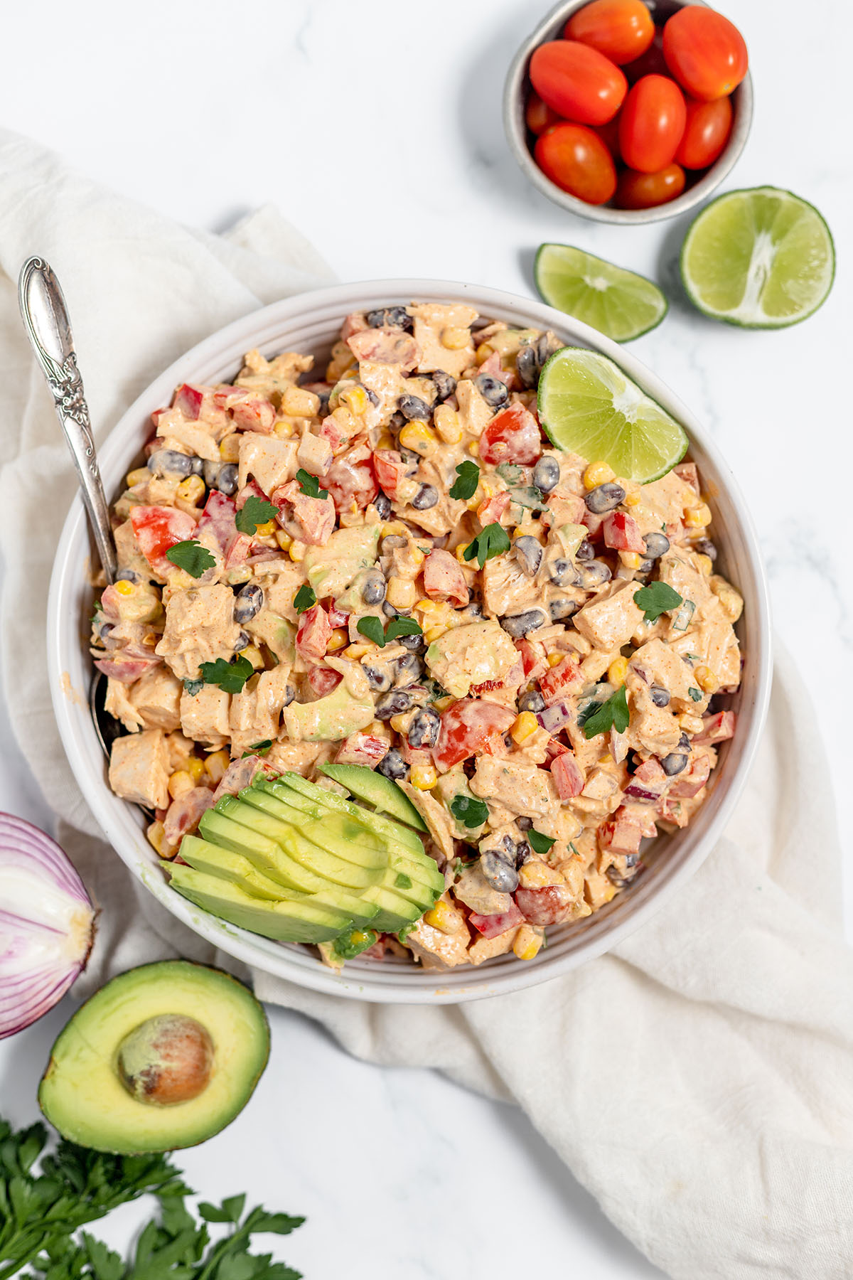Southwest chicken salad served in a white bowl with diced avocado.