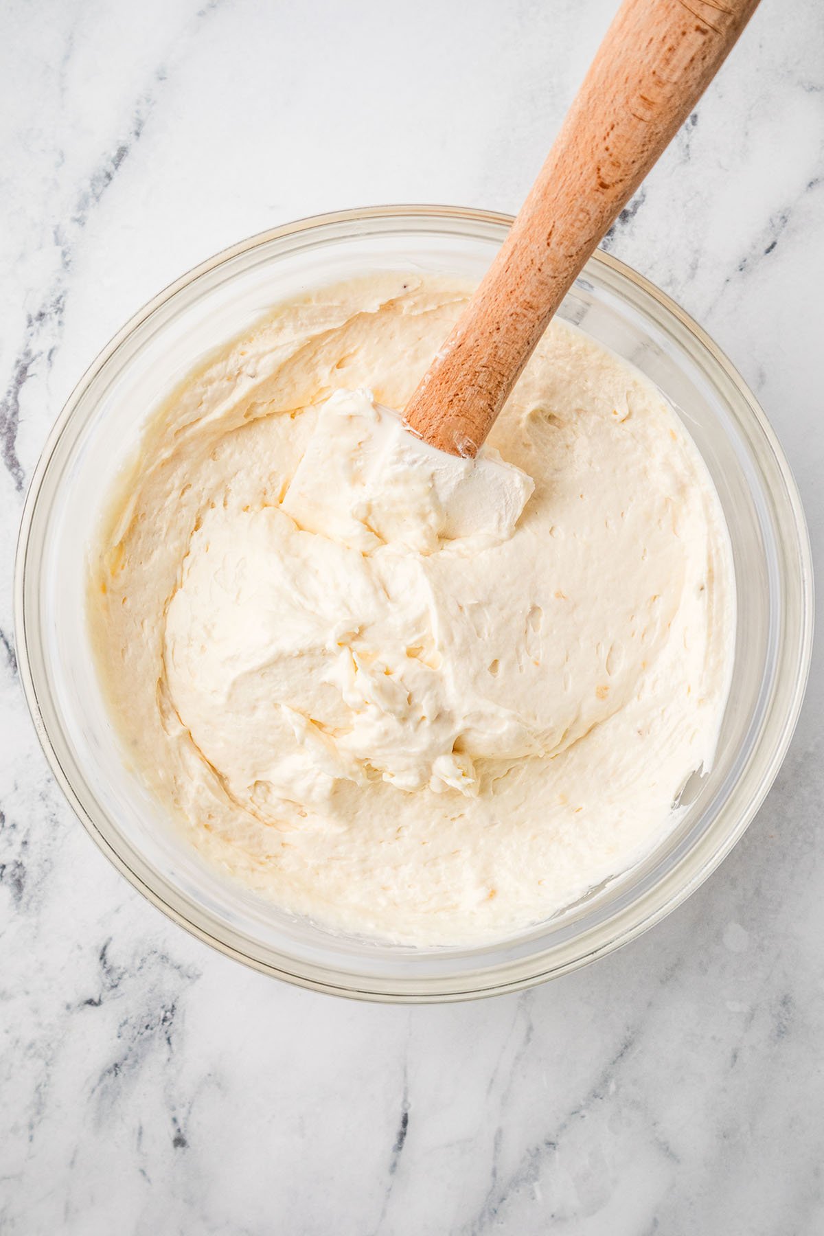 Banana cream cheese filling in a glass mixing bowl.