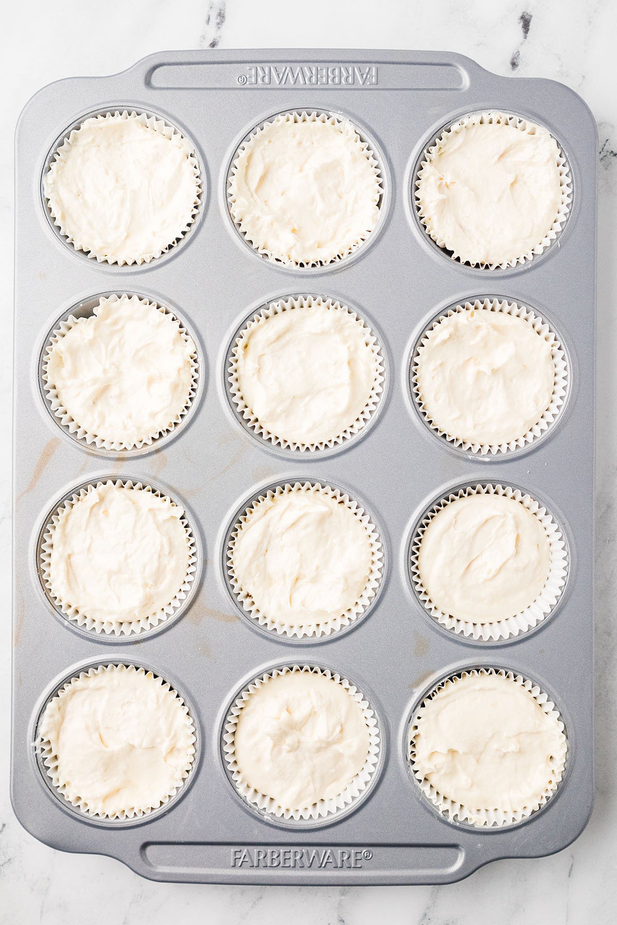 Banana cream cheese filling poured over the vanilla wafer crust in the muffin pan.