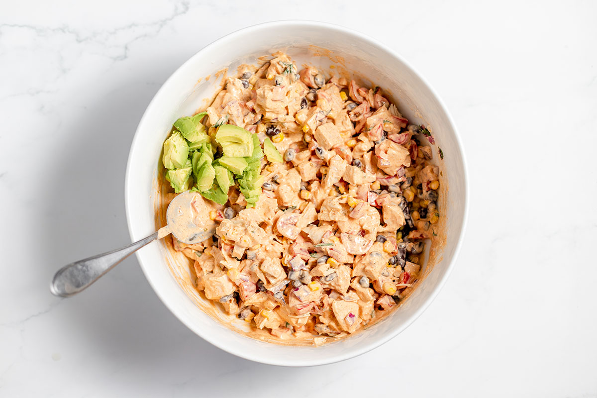 Diced avocado was added to the southwest chicken salad in the bowl.