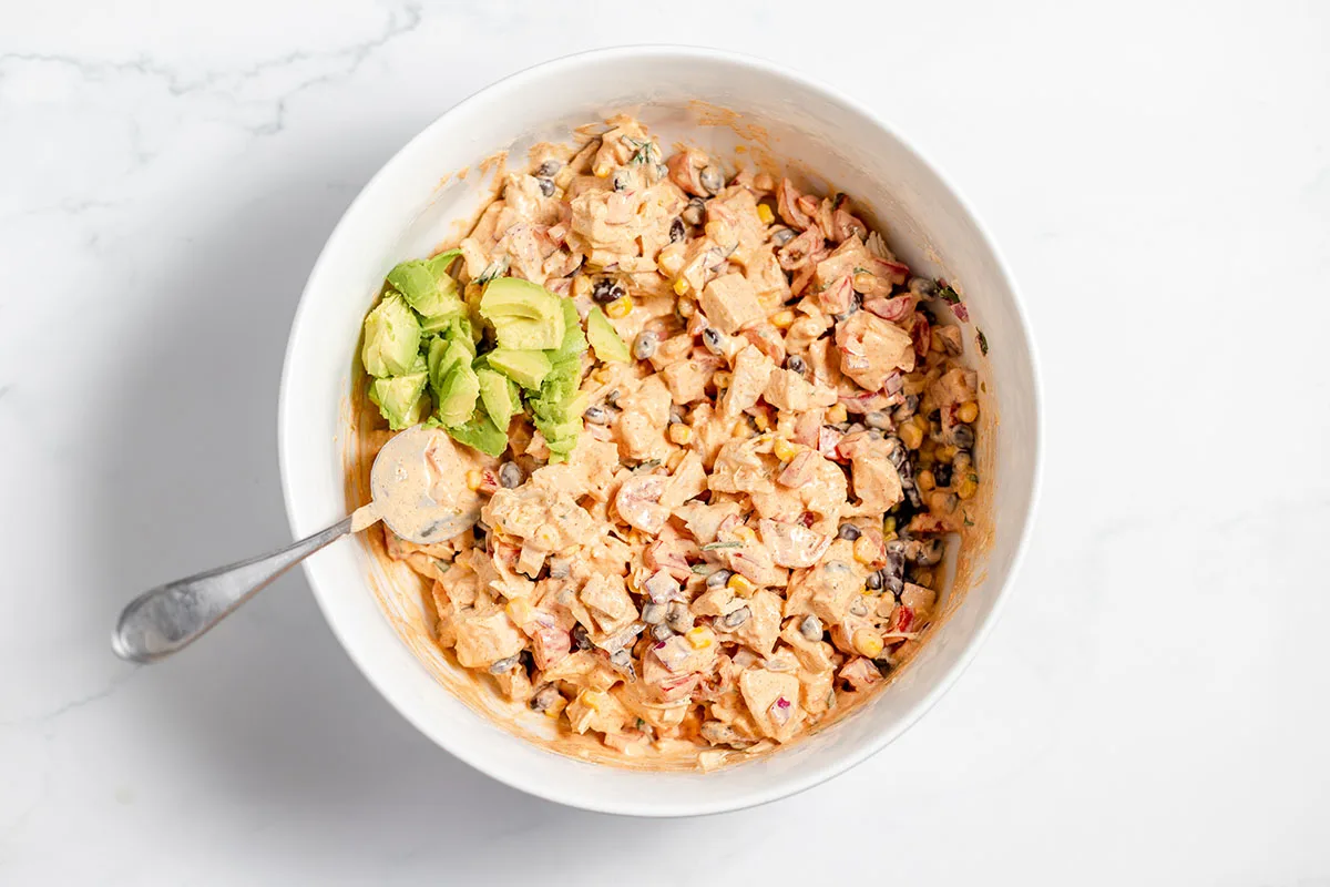 Diced avocado was added to the southwest chicken salad in the bowl.