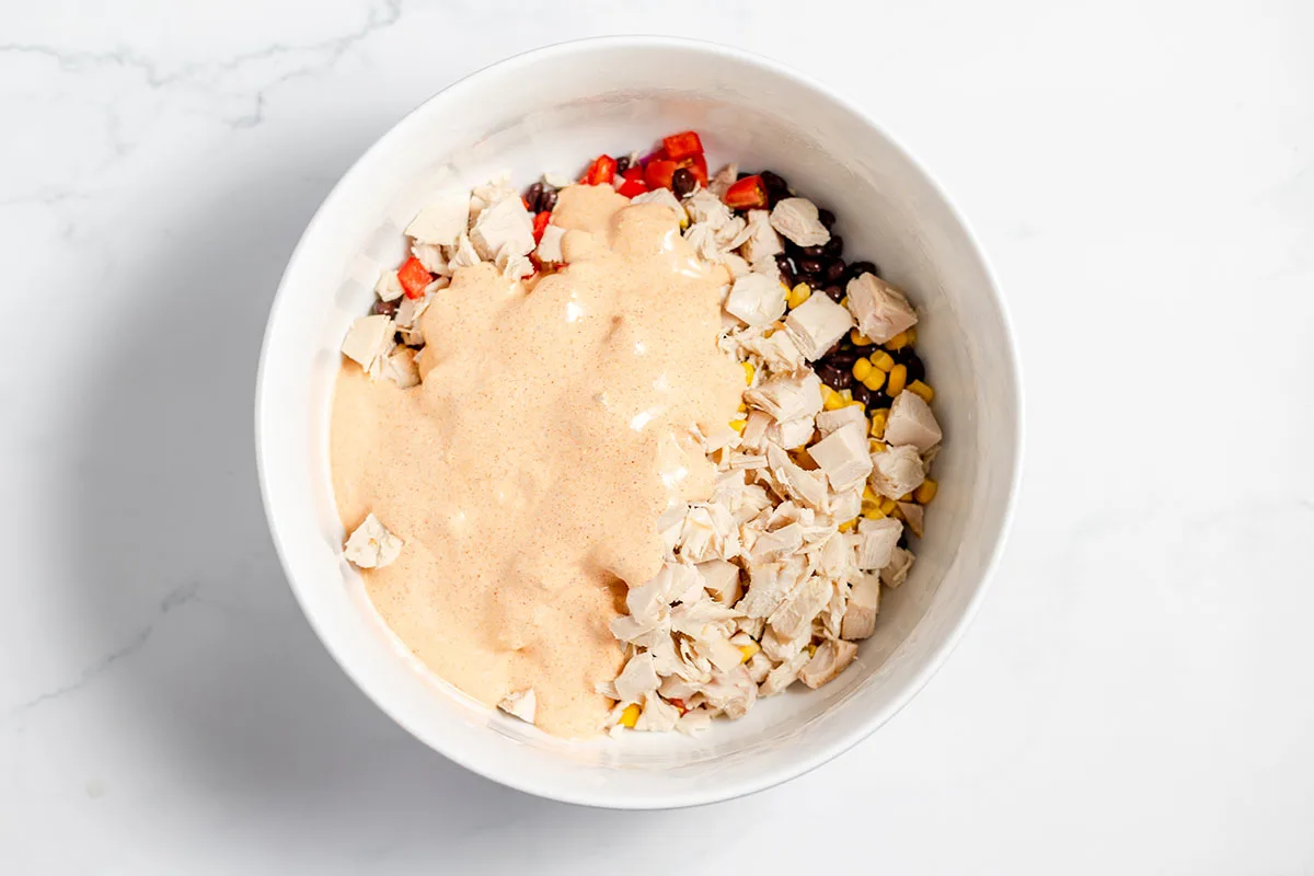Dressing poured over the southwest chicken salad in the bowl.