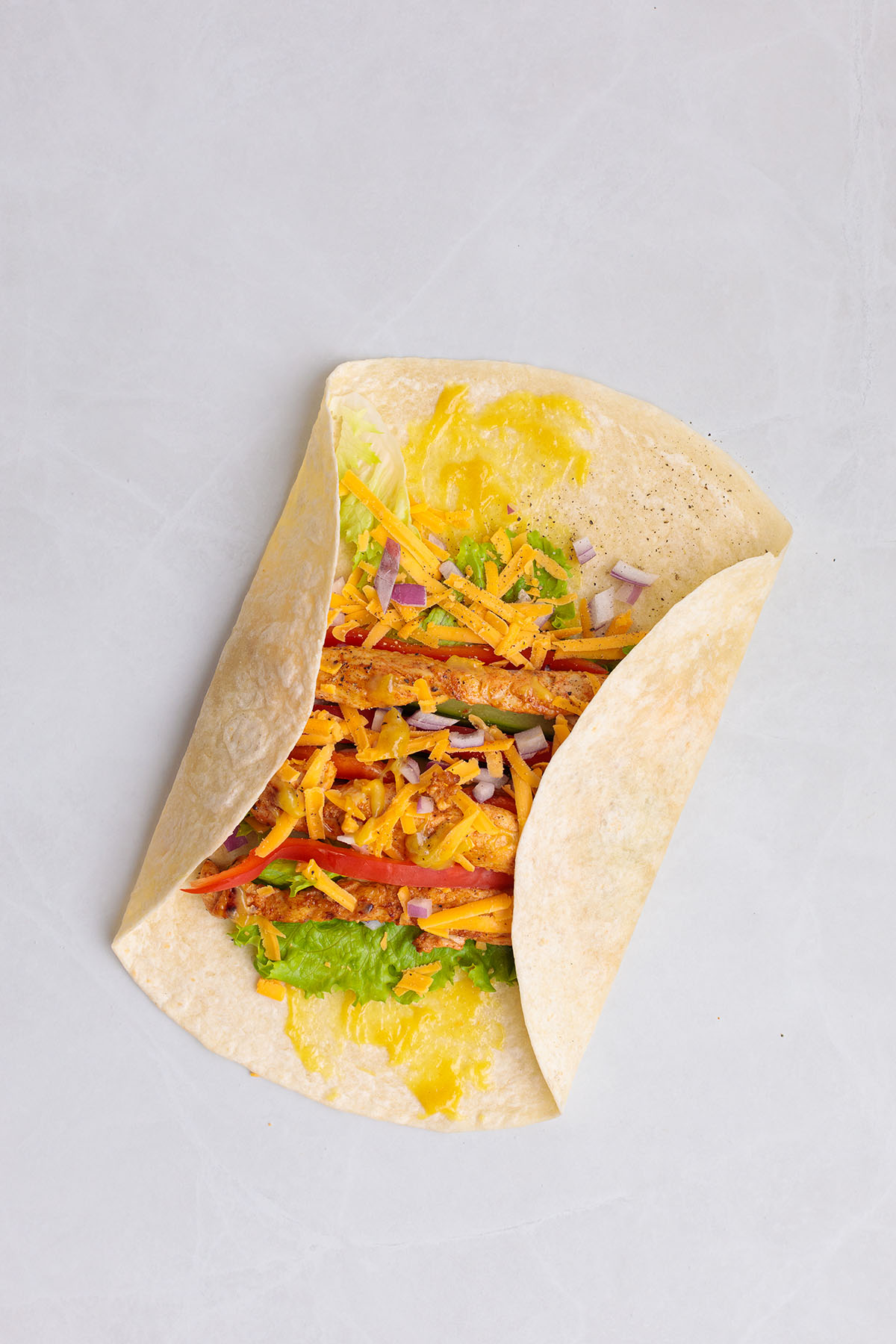 Folding in the sides of the flour tortilla around the honey mustard chicken filling.