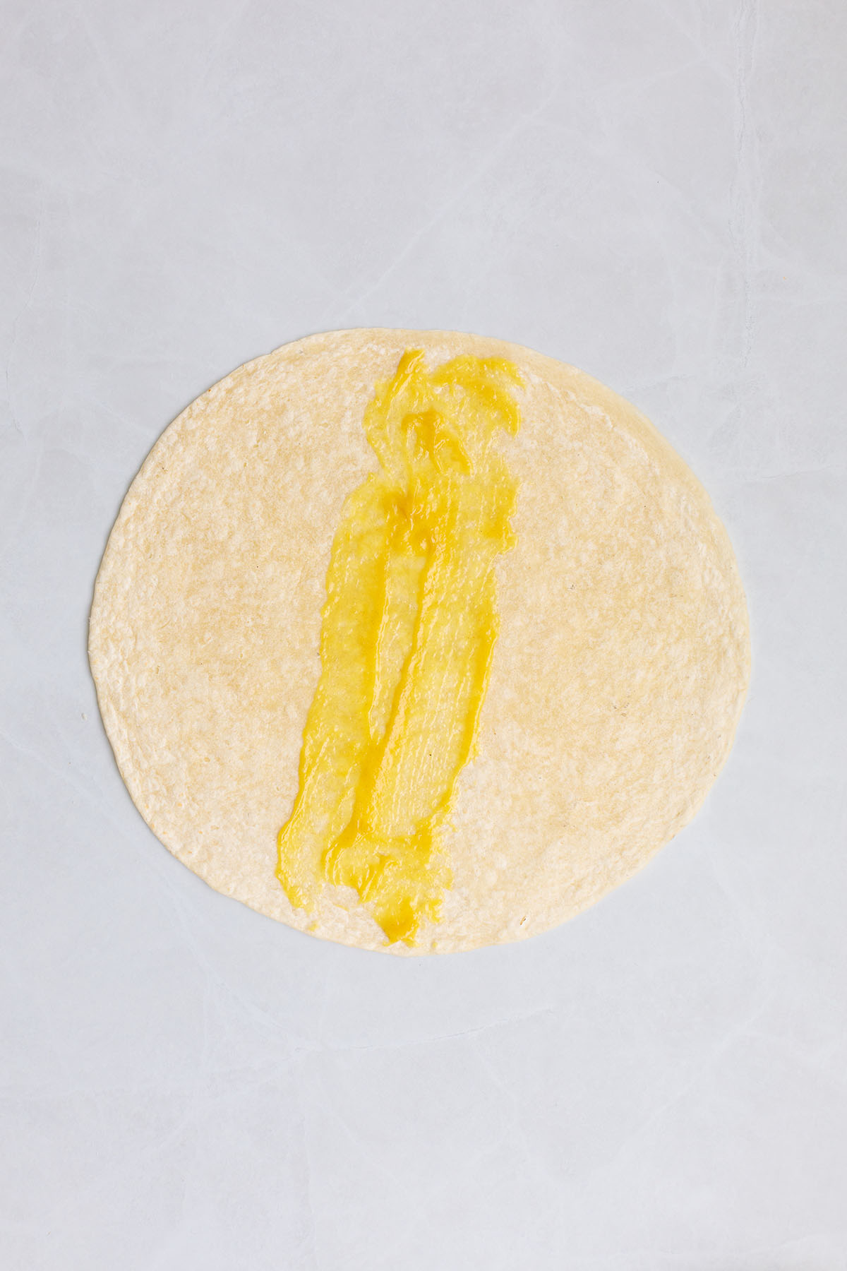 Honey mustard sauce spread over a flour tortilla.