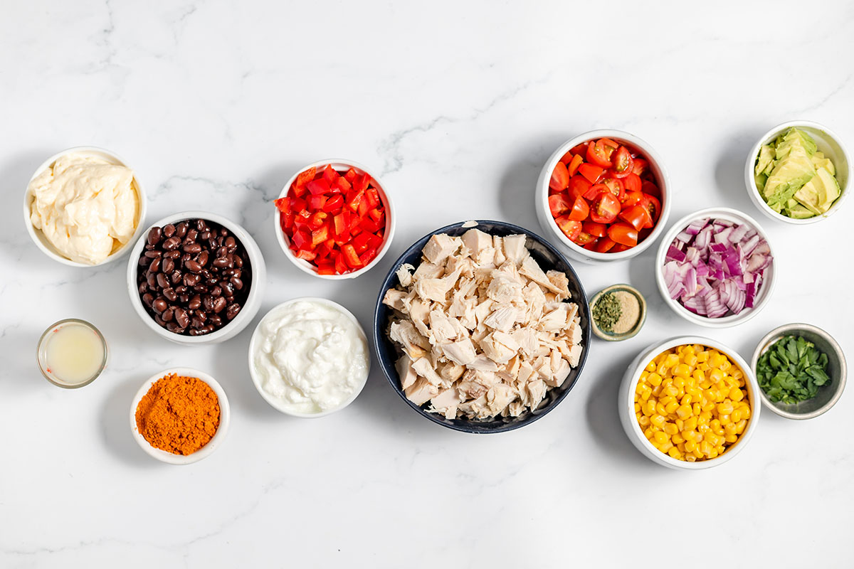 Ingredients to make southwest chicken salad tacos set out on the counter.