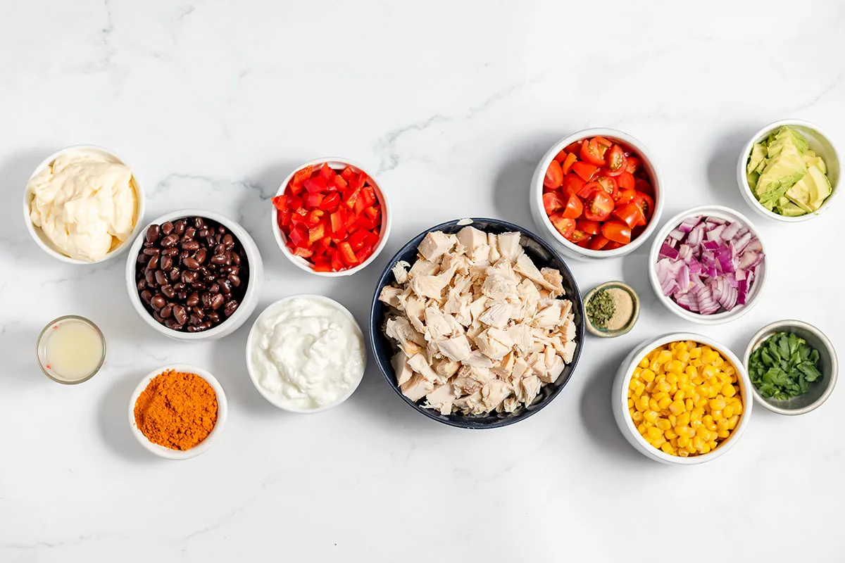 Ingredients to make southwest chicken salad tacos set out on the counter.