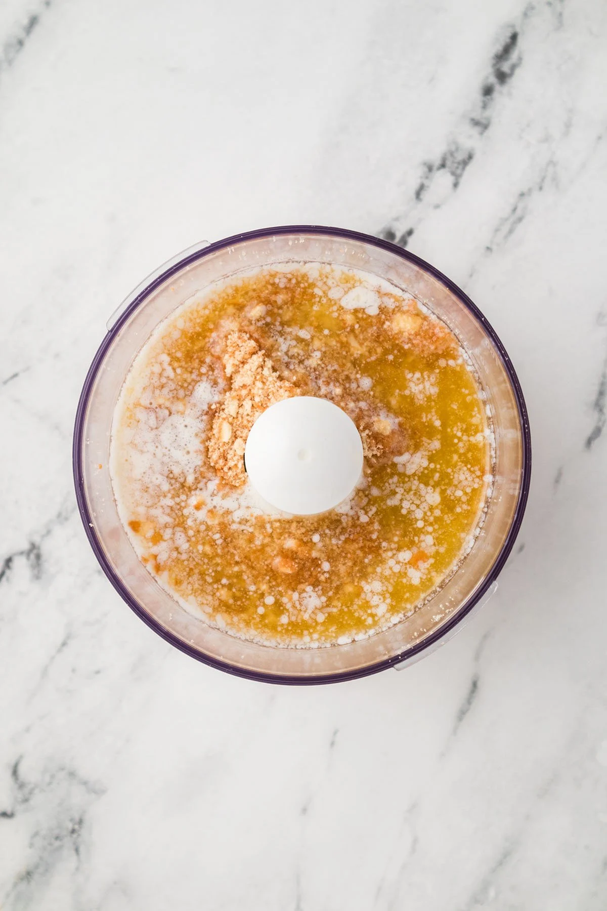 Vanilla wafer crumbs are mixed with butter in the food processor.