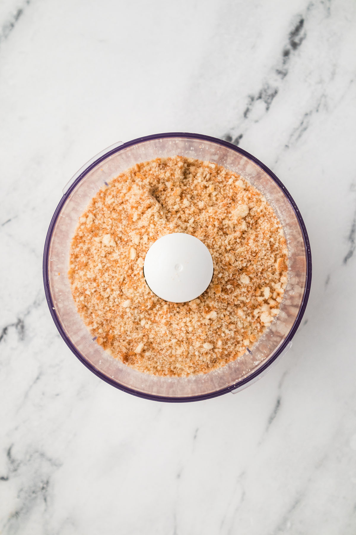 Vanilla wafers are crushed into crumbs in a food processor.