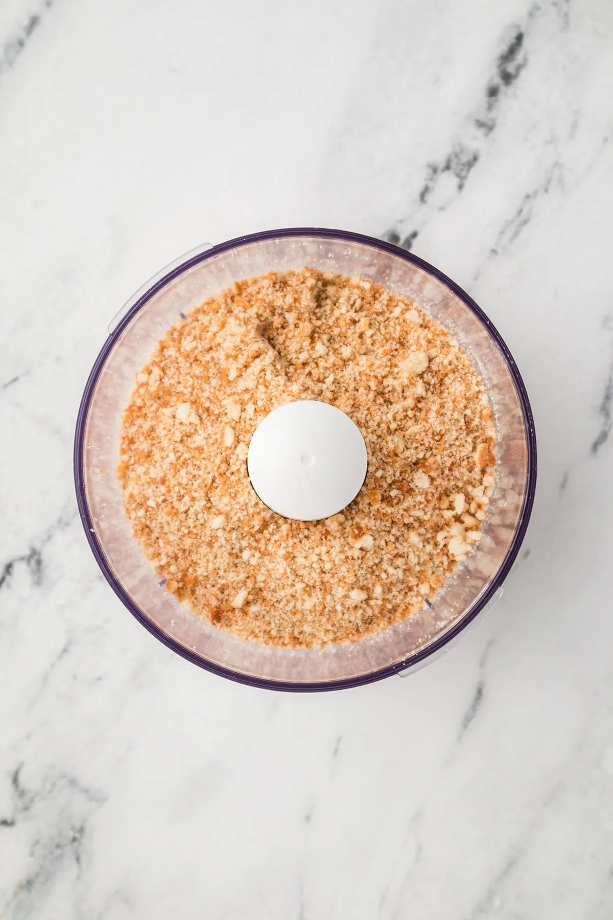 Vanilla wafers are crushed into crumbs in a food processor.