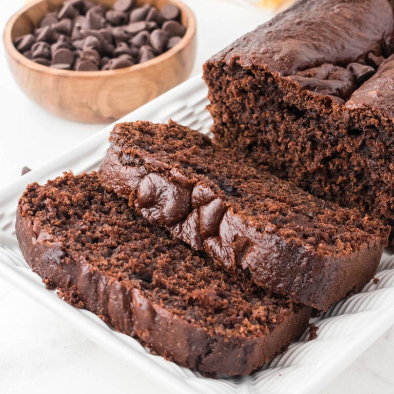 Chocolate Loaf Cake on a white platter with two slices cut.