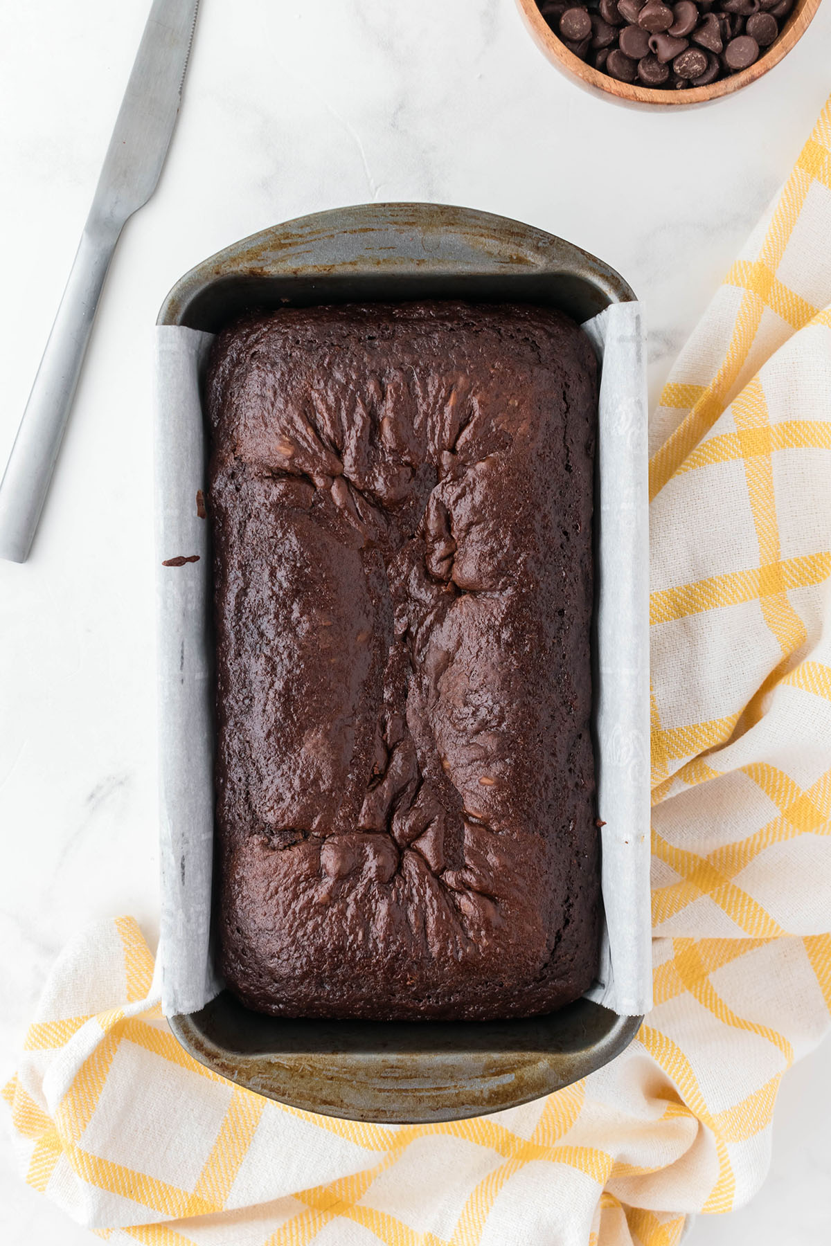 Chocolate Loaf Cake baked in a parchment paper lined baking pan.