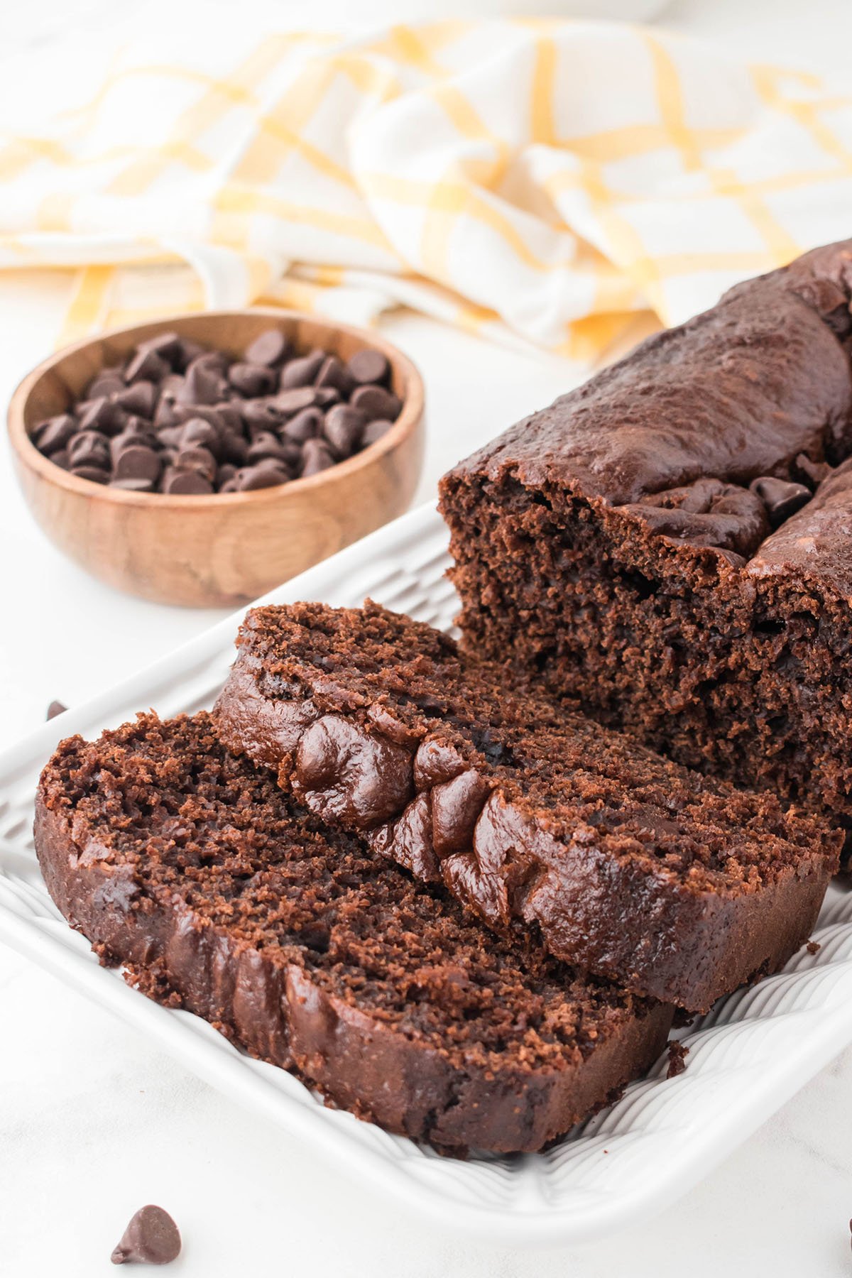 Chocolate Loaf Cake with two slices on a white platter.