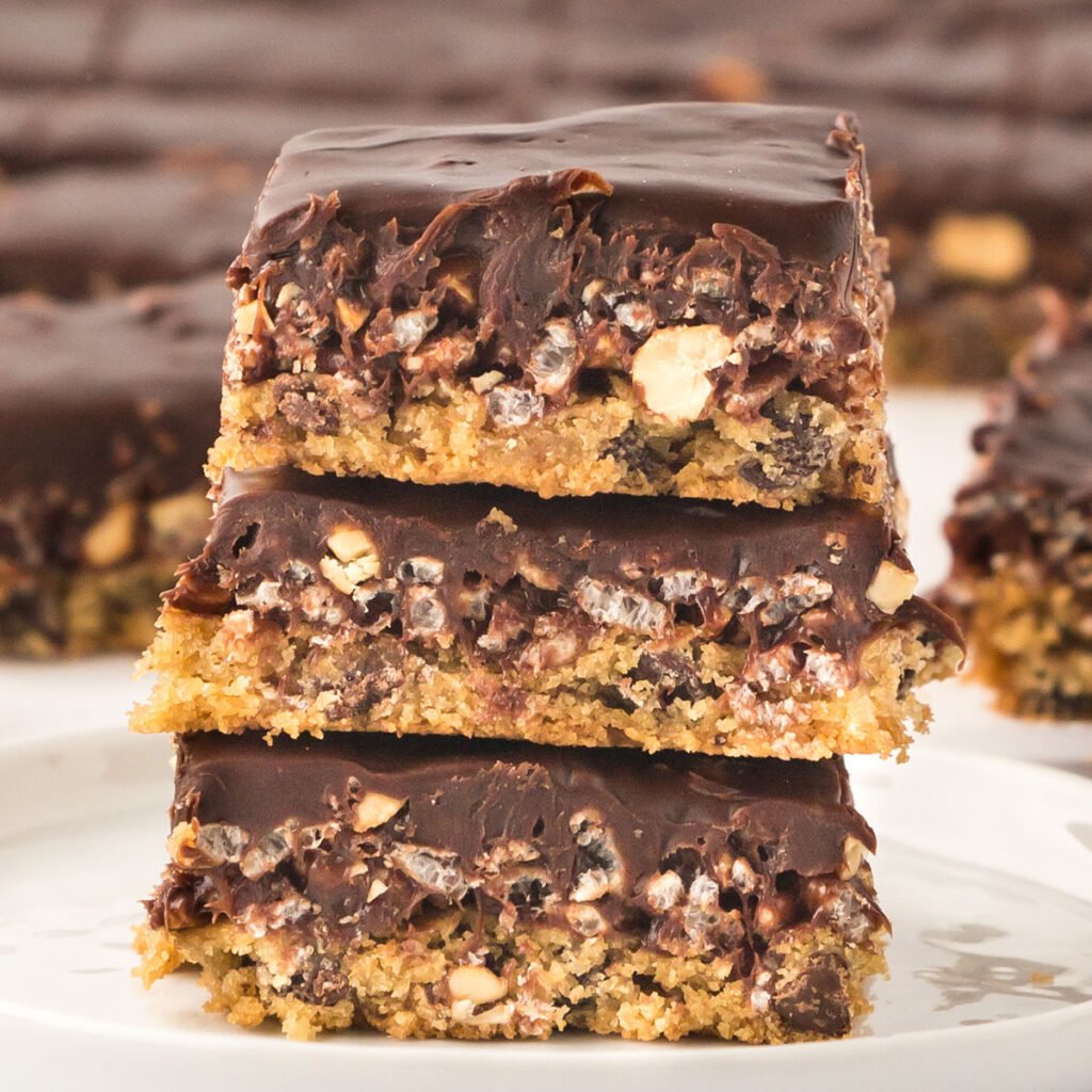 Three Caramel Cashew Bars stacked on a plate.