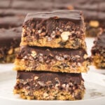 Three Caramel Cashew Bars stacked on a plate.