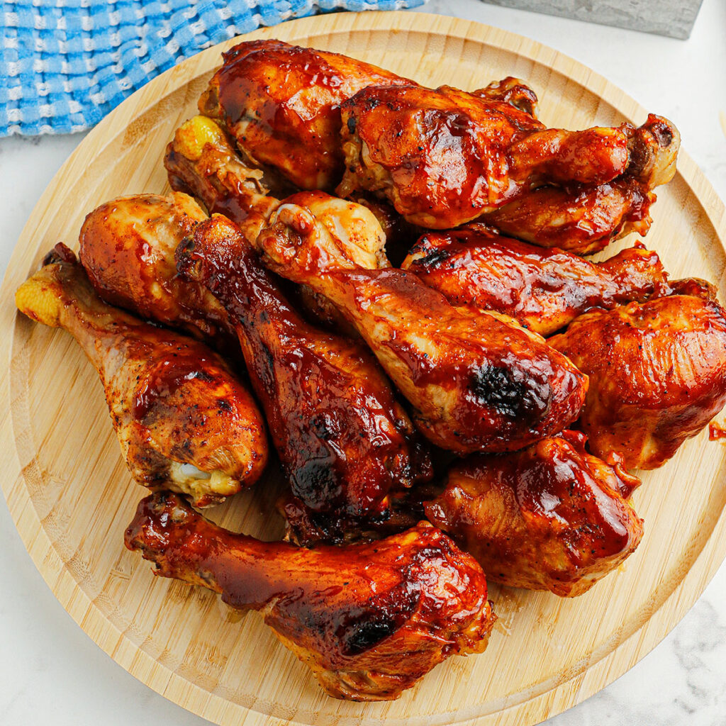 BBQ Chicken Drumsticks on a wooden serving board.