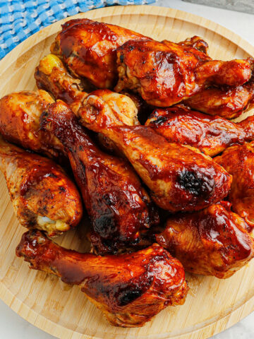 BBQ Chicken Drumsticks on a wooden serving board.