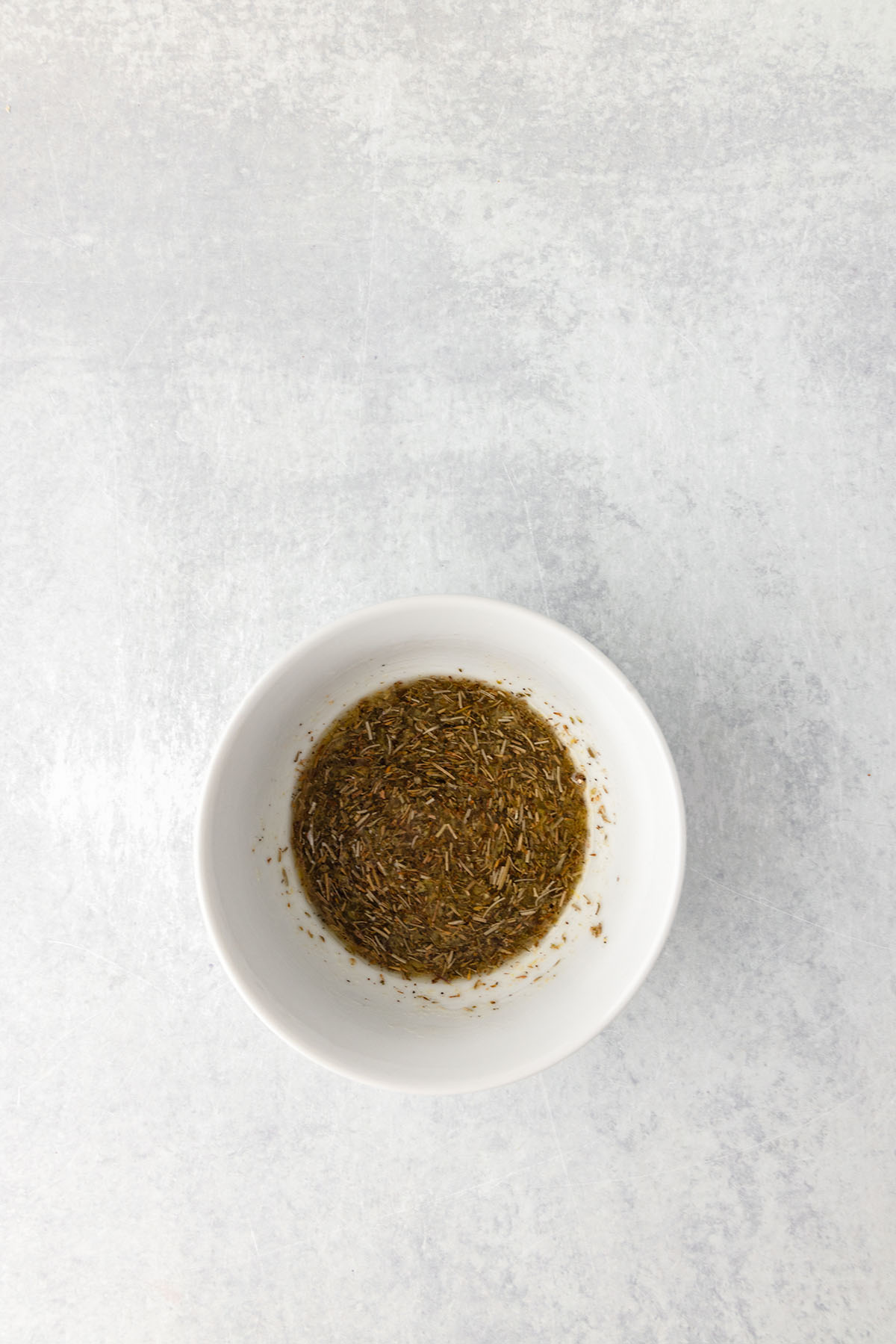 Lemon herb marinade was whisked together in a small glass bowl.
