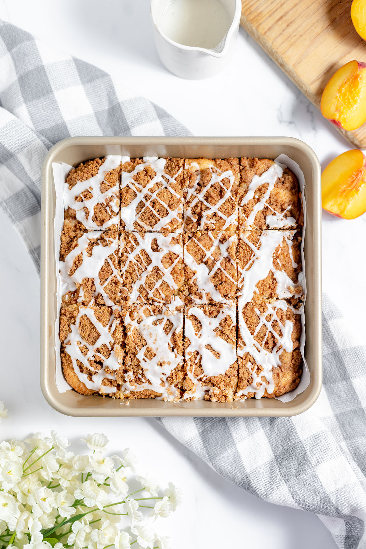 Peach coffee cake cut into slices in the baking pan and drizzled with icing.