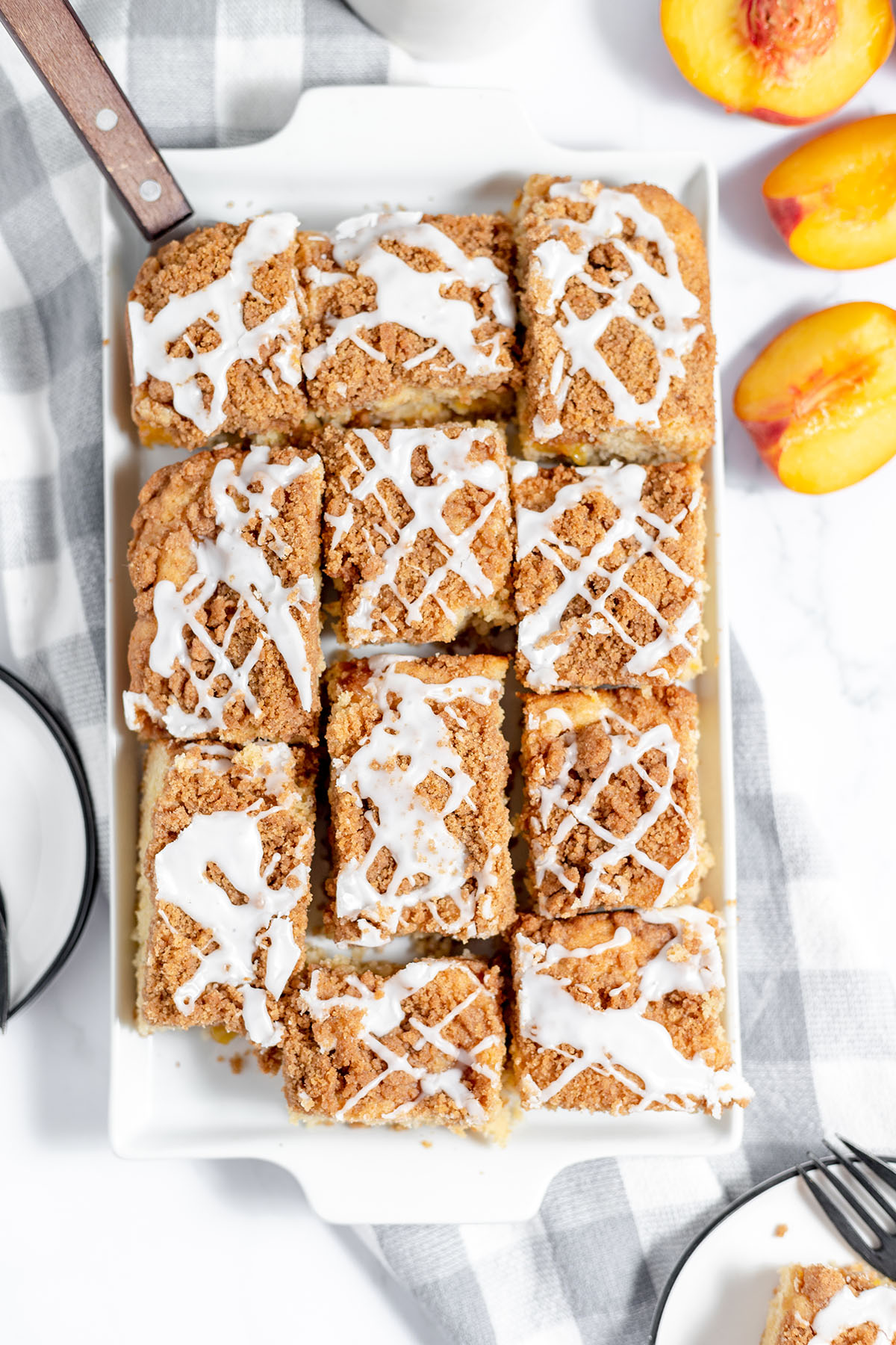 Peach coffee cake cut and served on a white platter.