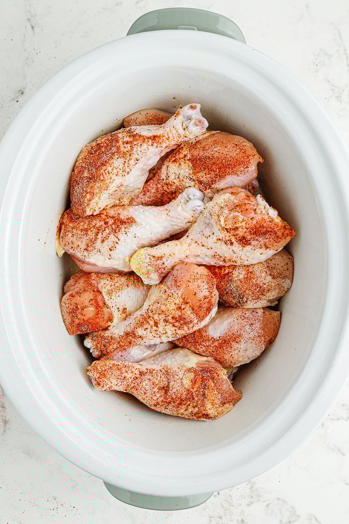 Seasoned drumsticks in the slow cooker.