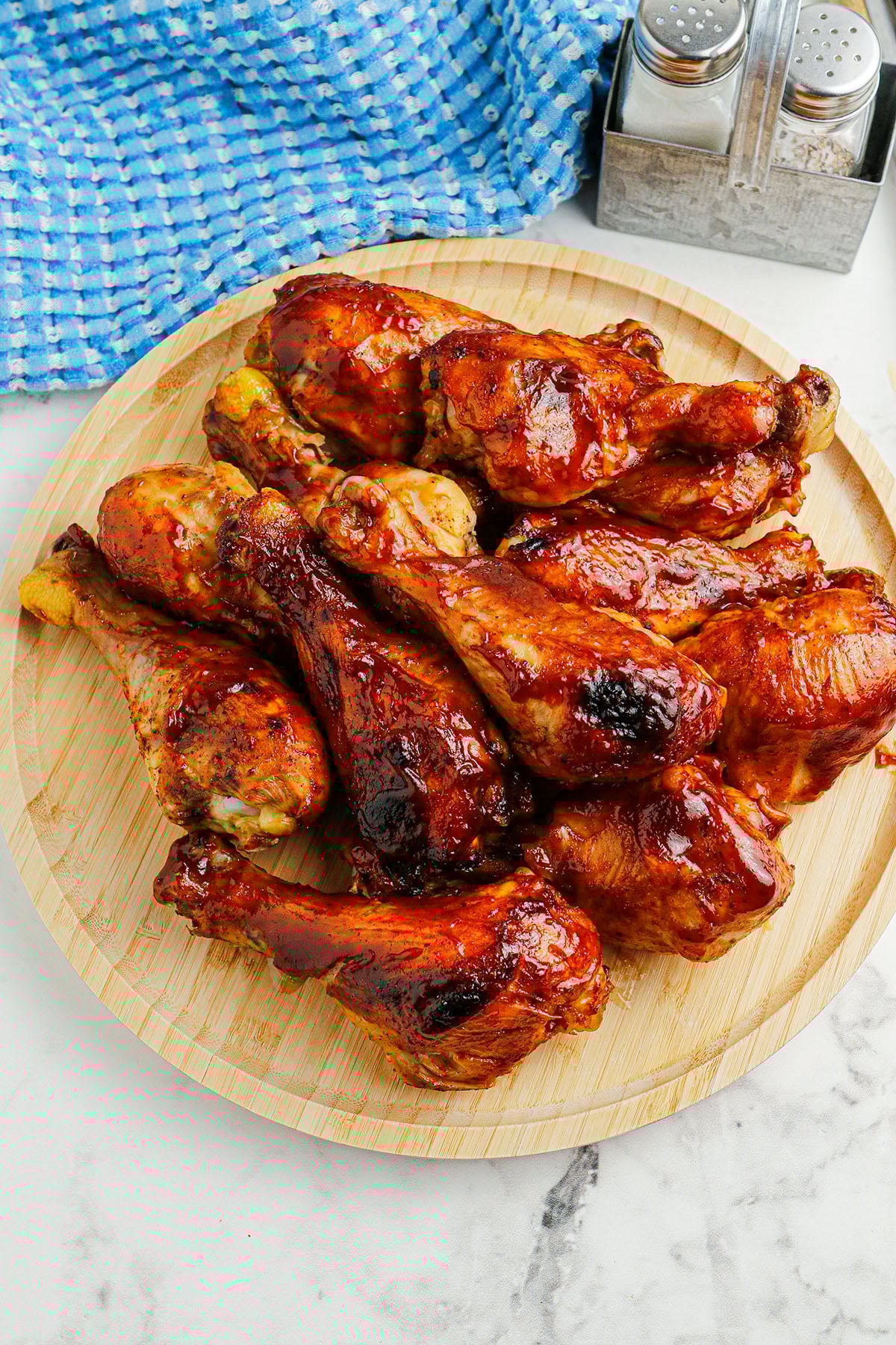 BBQ Chicken Drumsticks on a wooden serving board.