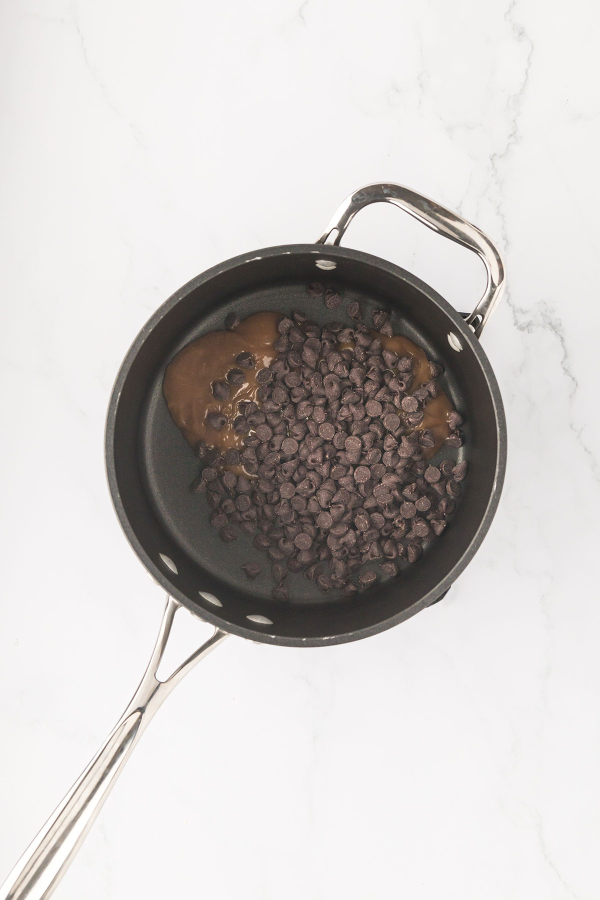 Chocolate chips and caramel dip in a saucepan.