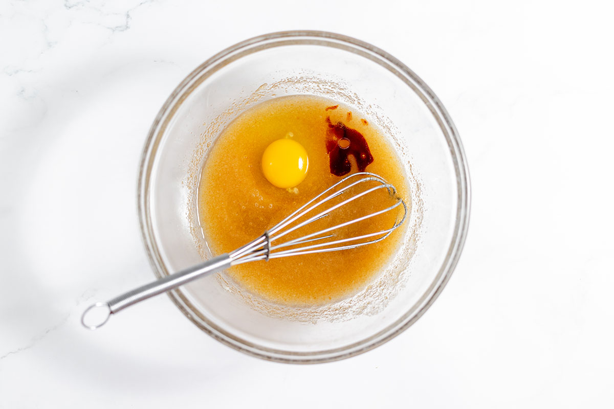 Egg and vanilla are added to the sugar mixture in the mixing bowl.