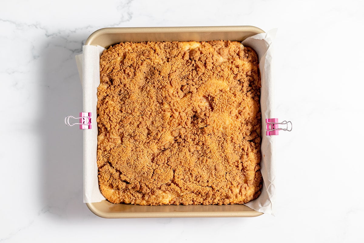 Peach coffee cake batter with a streusel topping in baking pan ready to put in the oven.