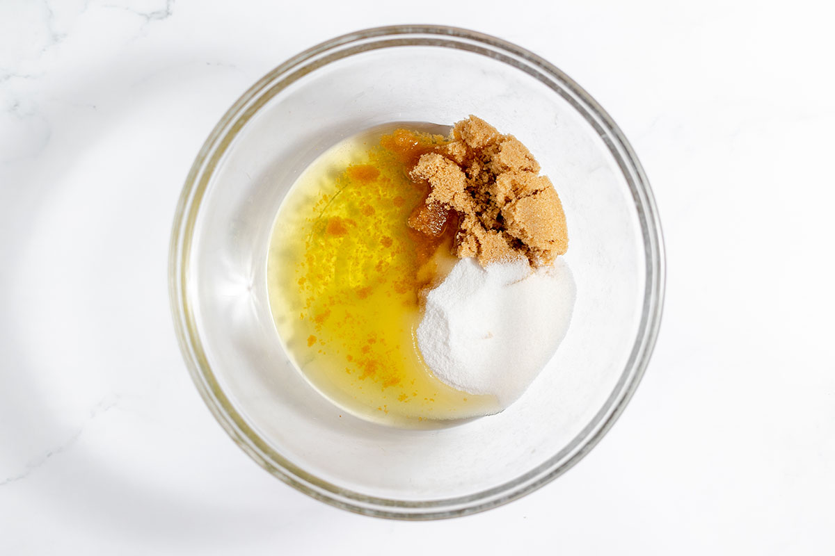 Sugar, brown sugar, and vegetable oil in a mixing bowl.