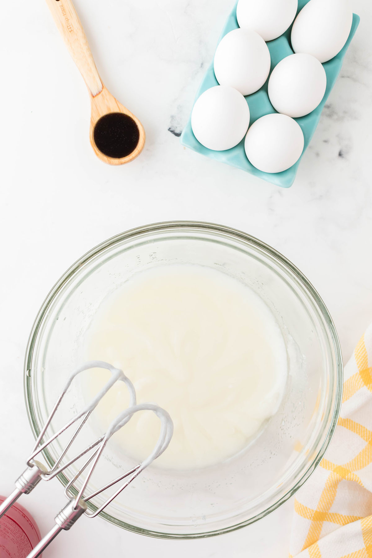 Vegetable oil, sugar, and sour cream in a glass mixing bowl.