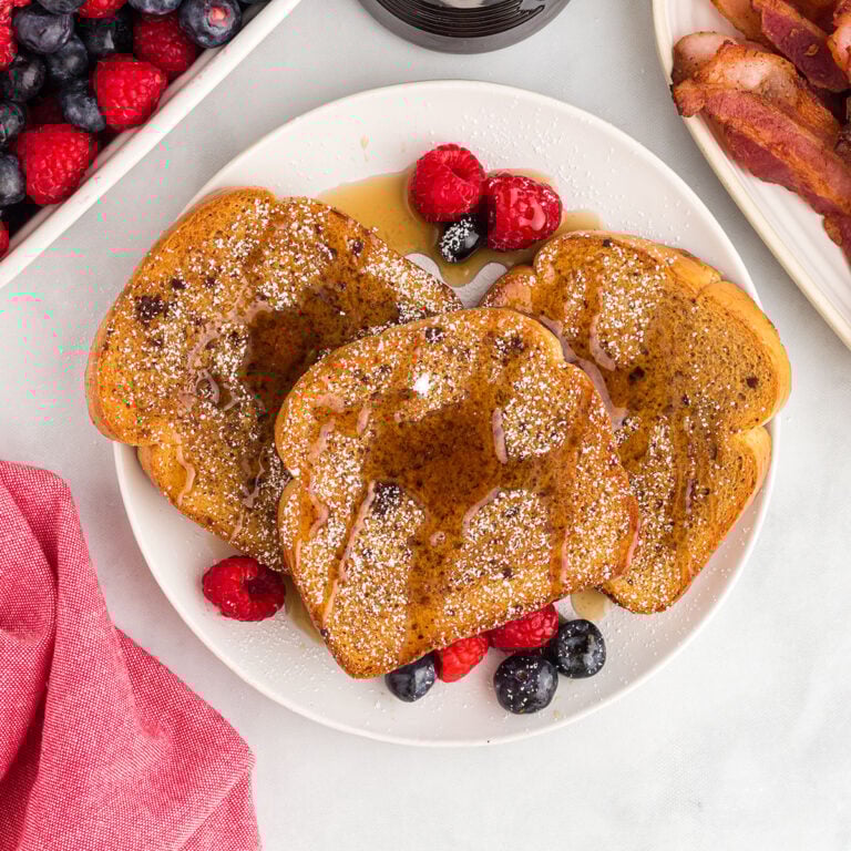 Three slices of Gingerbread French toast on a white plate.