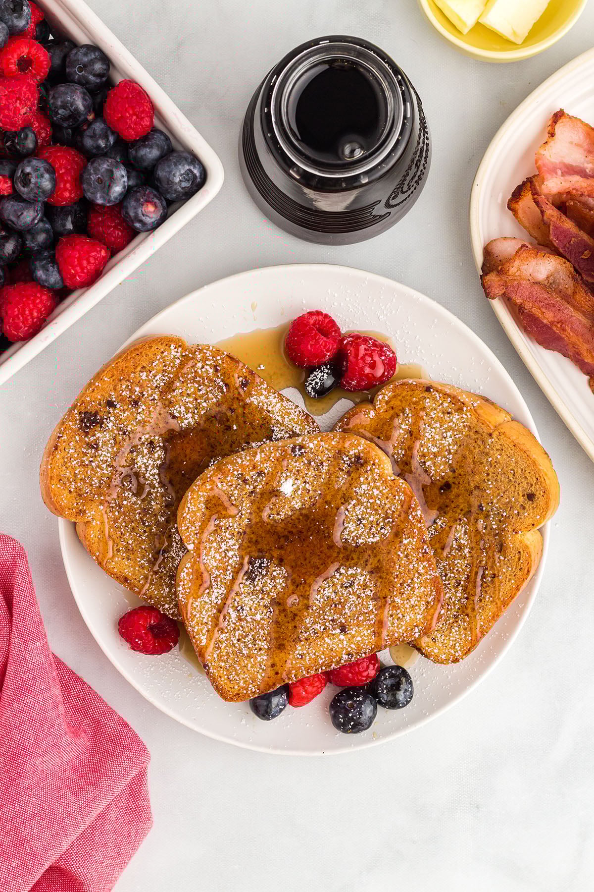 Three slices of gingerbread French toast topped with syrup on a white plate.
